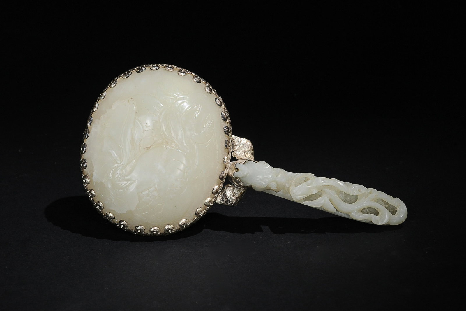 Chinese Hand Mirror with White Jade Plaque & Hook: A Chinese hand mirror inset with an 18th century white jade plaque and a white jade dragon hook. The dragon hook features a Chilong, and the plaque is carved with a pair of pomegranates. Dimensions ar