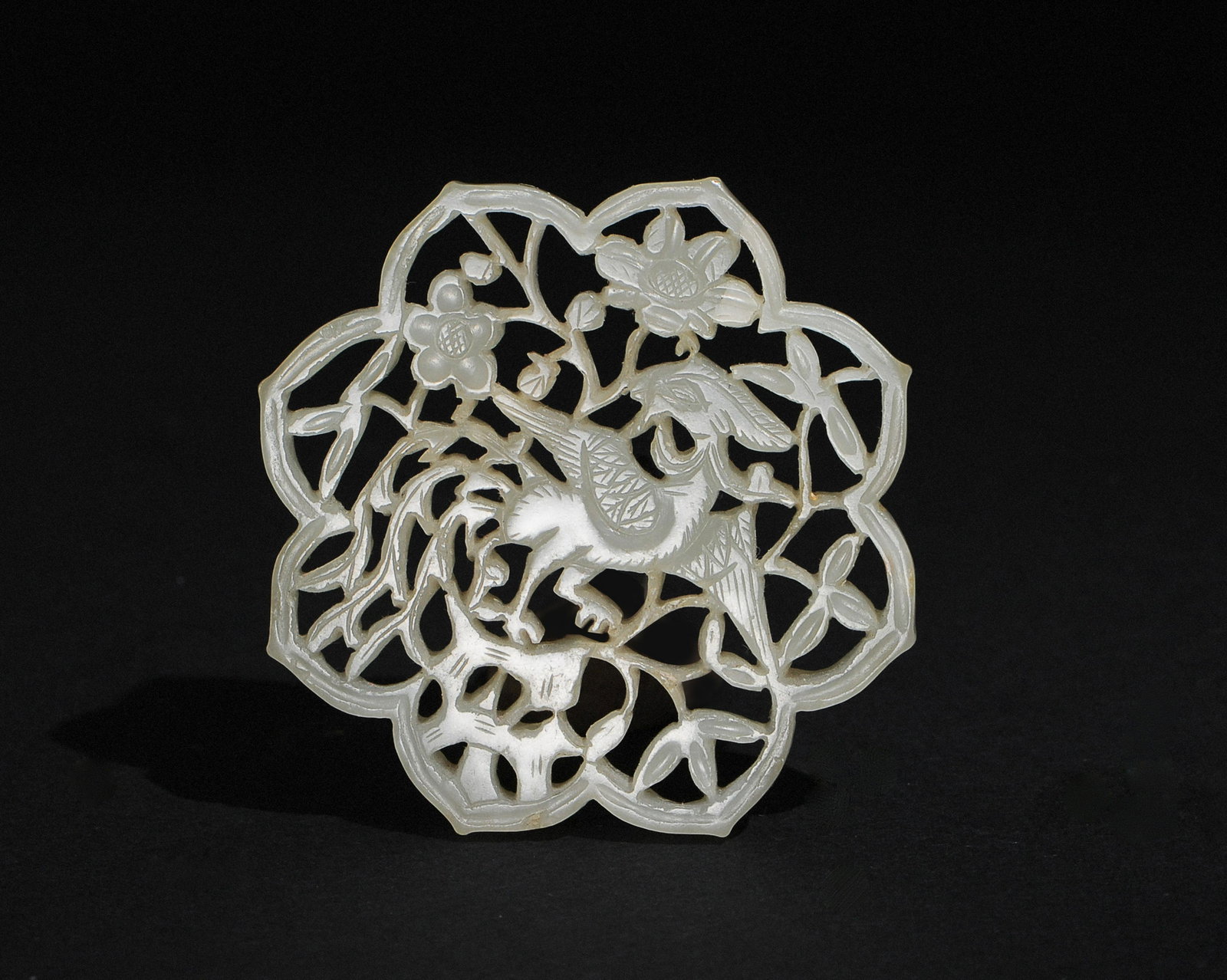 Chinese White Jade Carved Plaque with Phoenix, Ming: A Chinese octagonal jade plaque dating from the Ming dynasty. The plaque is cutout with a phoenix among flowers. Dimensions are: 3/16 inches tall X 2 inches wide. All measurements are approximate. Con