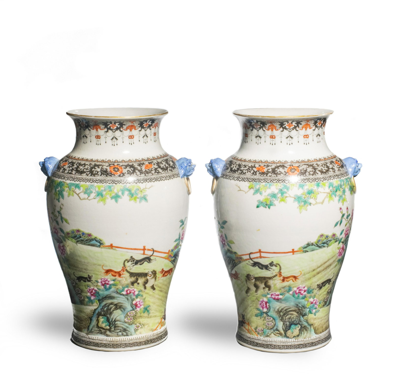 Pair of Famille Rose Hunting Scene Vases, Republic: A Chinese pair of famille rose porcelain vases with 4-character marks and dating from the Republic period. Each has a pair of blue guardian lion heads with wang characters on their foreheads holding a