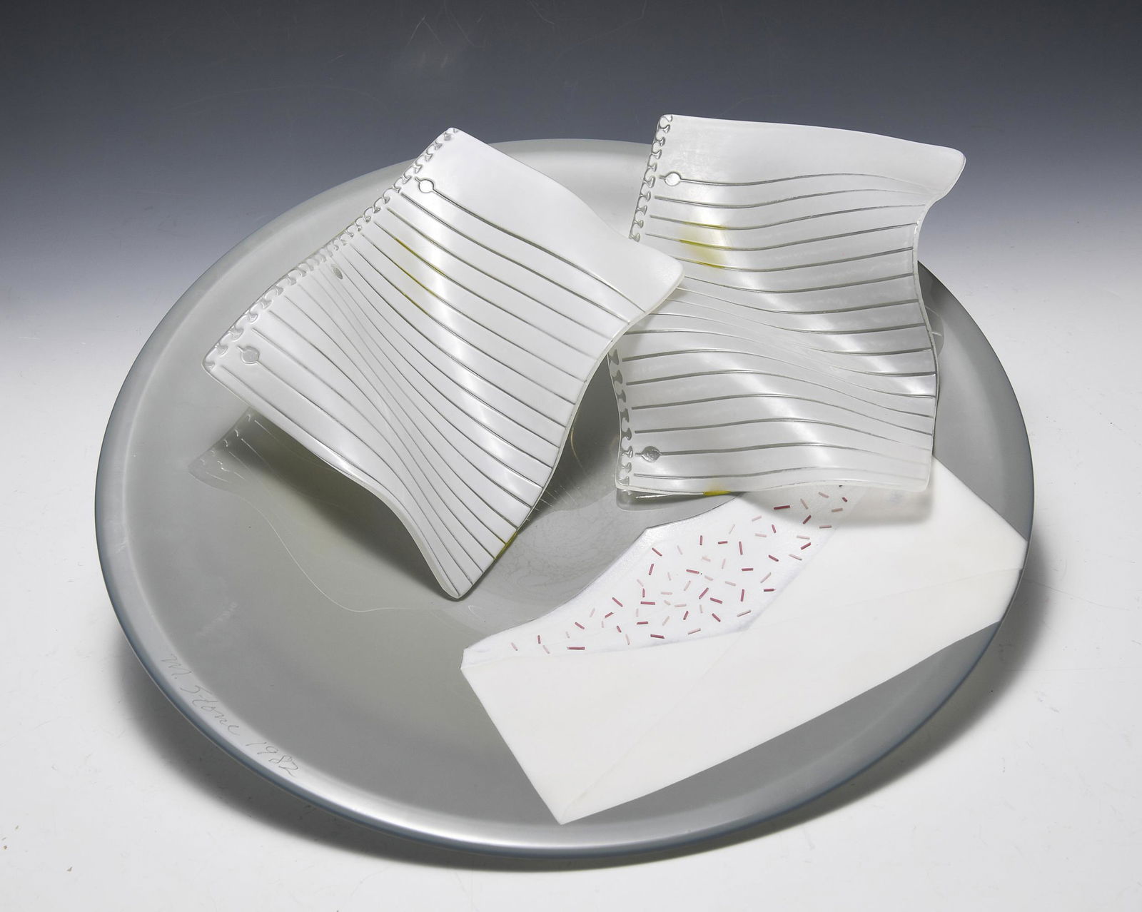 Cohn-Stone Studio Glass Charger: Art glass charger with glass loose-leaf paper and an envelope filled with confetti. From the studio of Cohn-Stone, which refers to artists Michael Cohn and Molly Stone based in Richmond, CA. Signed M.