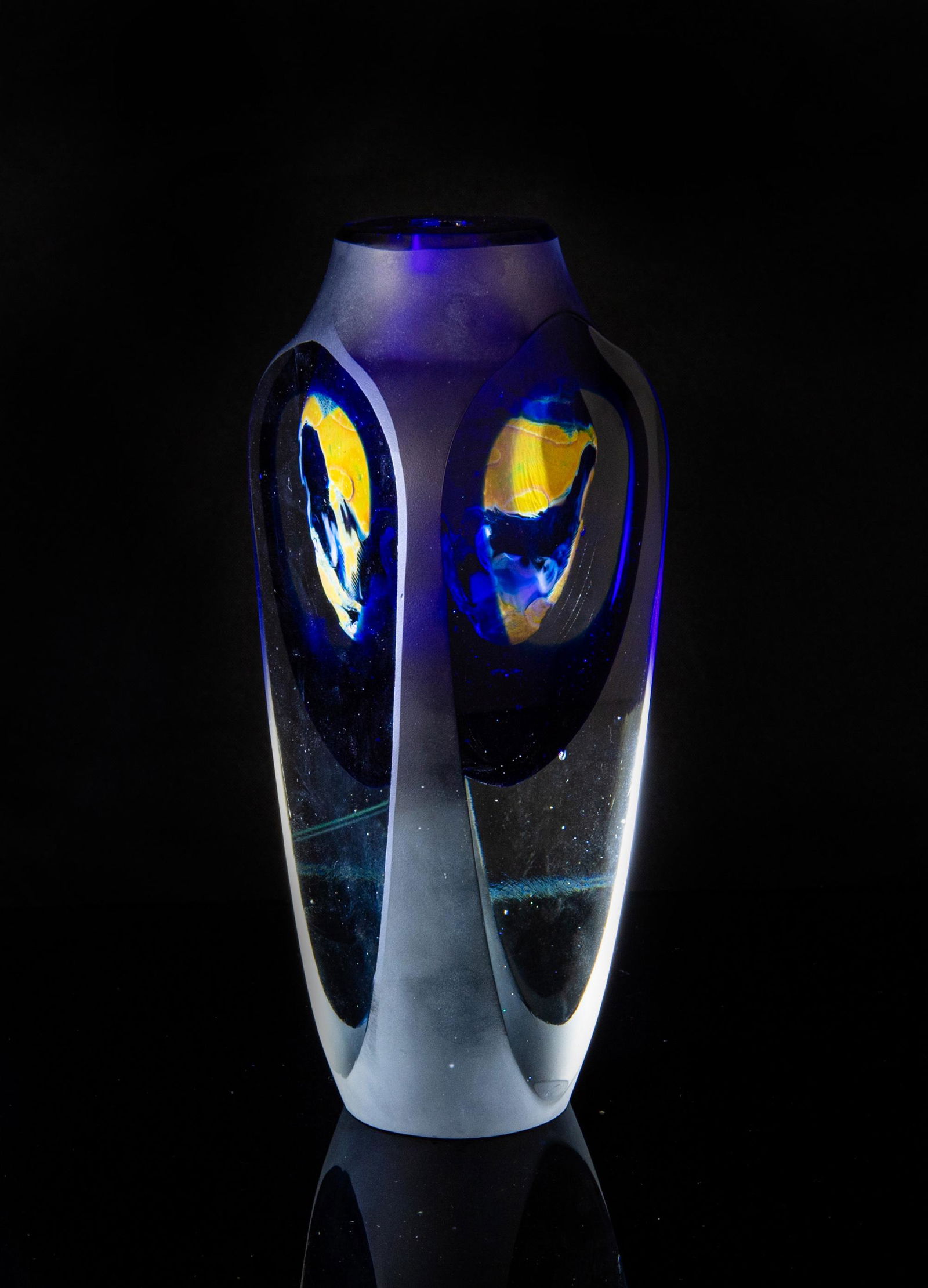 John Kuhn Studio Glass Floating Orb Vase: John Kuhn (American, 20th century) studio glass floating orb vase. Vase is clear glass on bottom half and the top half has cobalt blue glass encasing a sand-colored orb. Signed John Kuhn, April '79 on
