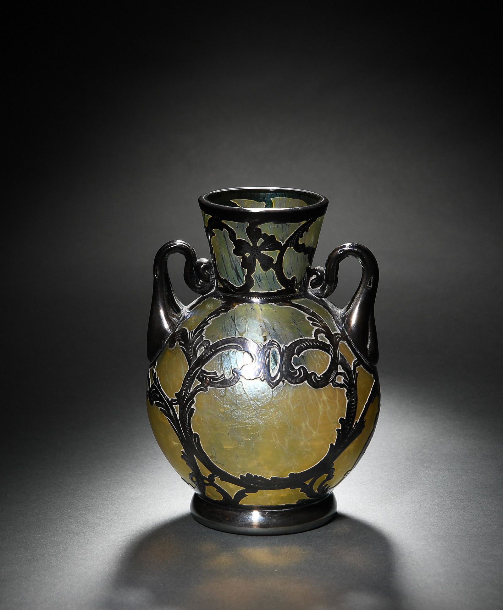 Loetz Art Glass Iridescent Vase - Sterling Overlay: Loetz art glass iridescent vase with sterling overlay. Iridescent green vase that has a 925 sterling silver overlay and handles. Dimensions are: 5 1/8 inches tall X 4 inches diameter. All measurements