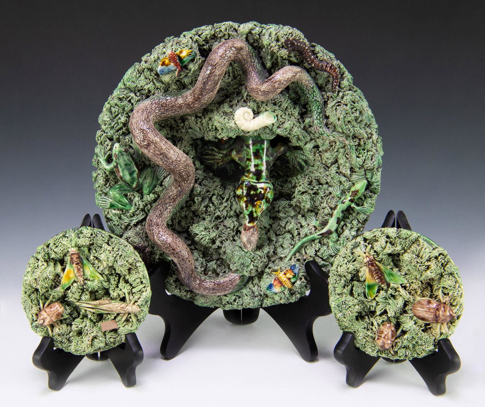 (3) Majolica Palissy Ware Plates by Jose A. Cunha: Late 19th century majolica palissy plates by Jose Alves Cunha. Largest is signed on verso. Dimensions are: largest - 11 inches diameter X 3 1/2 inches tall. All measurements are approximate. Condition