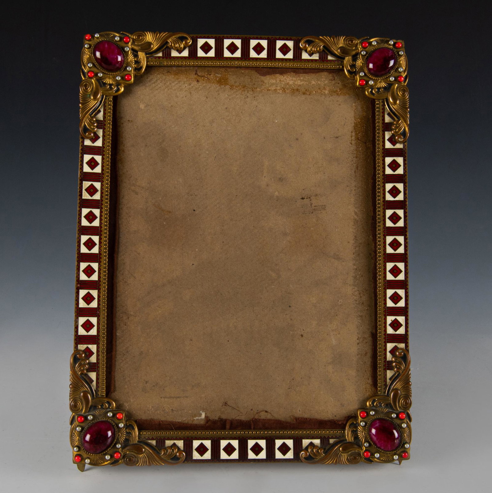 Antique Enameled & Jeweled Brass Frame: Antique cloisonne enameled and jeweled brass frame. Unmarked, set with quartz, coral and moonstones at corners; hinged stand attached to upper back; backboard covered in cotton fabric. Dimensions are: