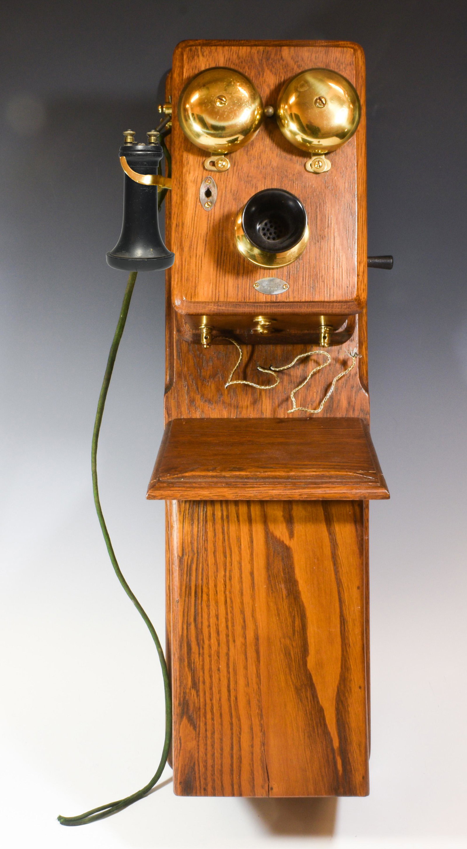 Antique Manhattan Electric Co. Oak Wall Phone: Antique Manhattan Electric Company oak wall phone. Generator intact. Dimensions are: 24 3/4 in (62.9 cm) tall X 7 in (17.8 cm) wide X 7 1/10 in (18 cm) deep. All measurements are approximate. Conditio