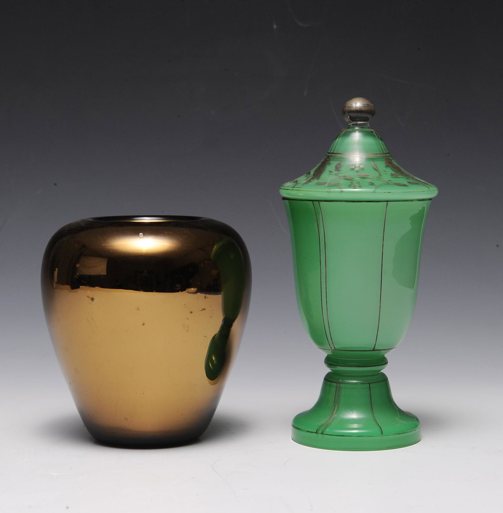 (2) Czech Glass, Inc. Vase & Jar: (2) Czech glass, including vase and jar: a) green jar with a lid decorated with silver birds, b) bronze-colored vase. Both are stamped with "Czechoslovakia." Dimensions are: largest 7 1/2 in (19.1 cm)