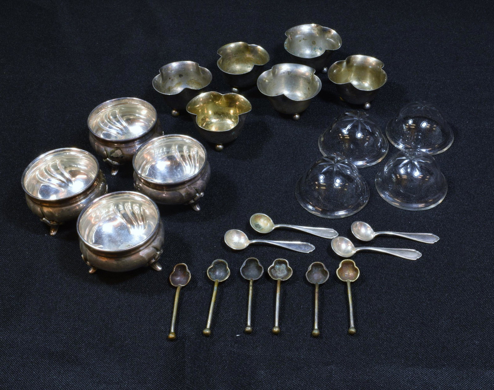 (10) 800 & 835 Coin Silver Open Salts with Spoons: (10) 800 and 853 coin silver open salts with spoons: a) four metal stands with glass bowls and spoons; b) six metal only bowls with spoons. Weight: 223.4 grams. (7.2 ozt). Dimensions are: smallest- 1 