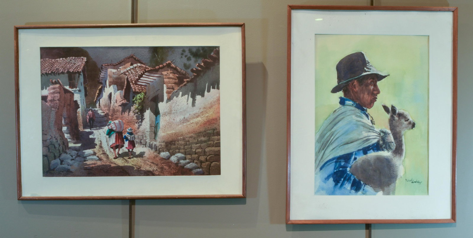 (2) Peruvian Watercolor Paintings, Late 20th C: (2) Peruvian watercolor on paper paintings, 20th century: a) unknown artist, man in in hat with baby alpaca, signed in lower right corner [Marcus Sun...?]; b) possibly Florentino Bellota, street scene