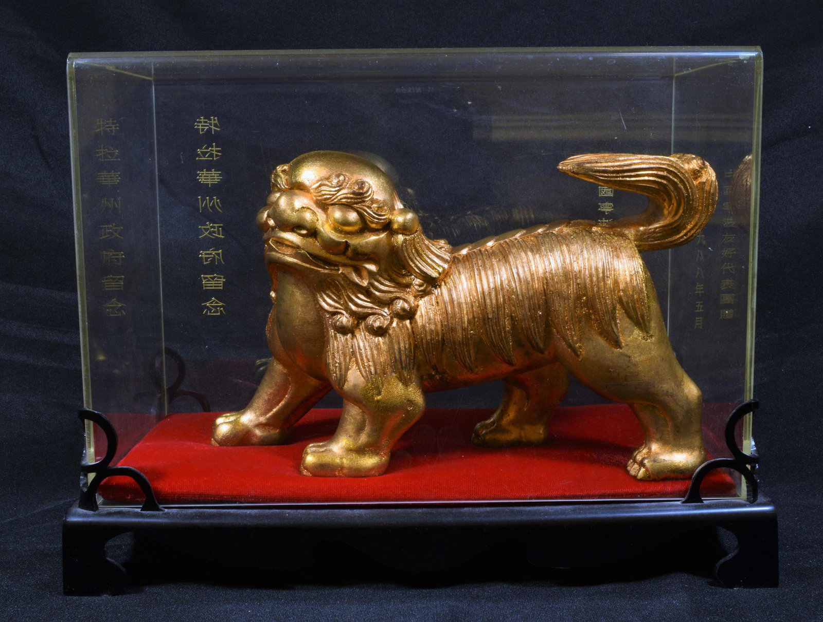 Carved Chinese Qilin Presented from Ningbo: Carved Chinese Qilin presented from the Chinese province of Ningbo, from the 20th century. The Qilin is shown striding with tail up. Dimensions are: in display case - 9 1/2 inches (24.1 cm) tall X 12 