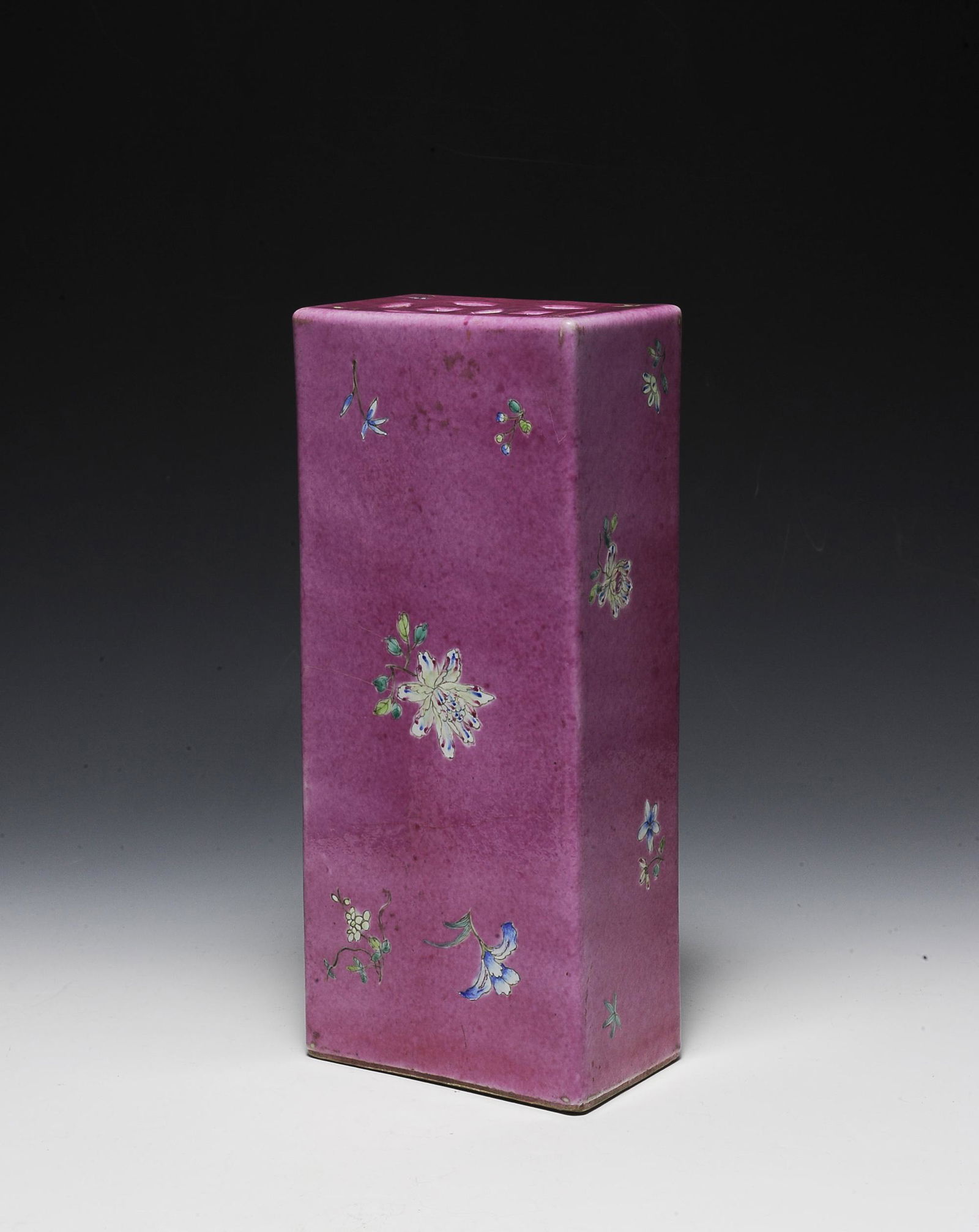 Chinese Porcelain Hat Stand, Republic Period: A Chinese porcelain hat stand dating from the Republic period. The hat stand is pink ground, with famille rose flowers and 2 lucky coin cut-outs on top, and a quatrefoil cut-out on the bottom. Dimensi