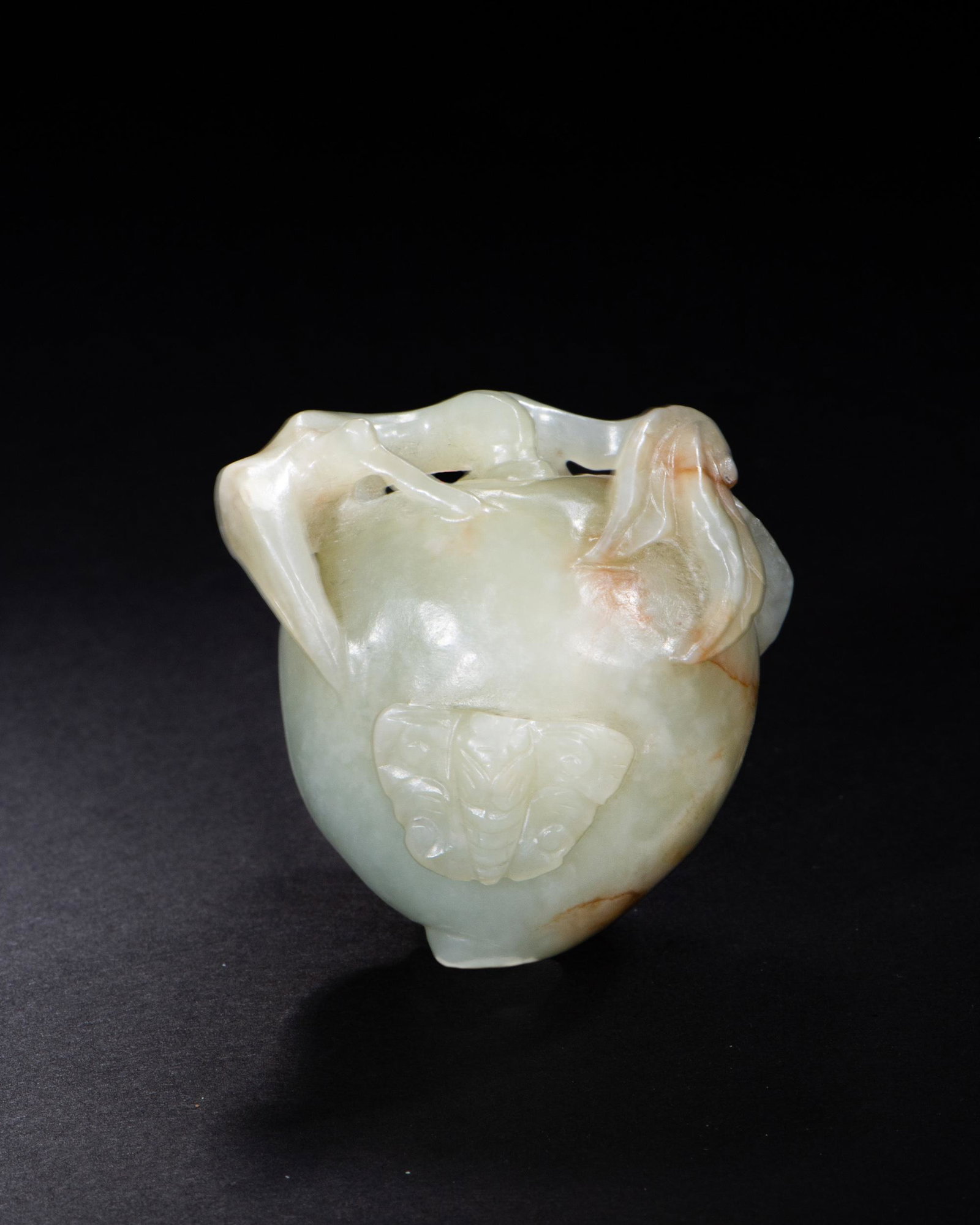 Chinese Jade Carving of Peach, Ming: A Chinese jade carving dating to the Ming dynasty. The carving features a peach with a butterfly and leaves. Dimensions are: 1 3/4 in tall X 1 3/4 in. wide; 4.4 cm tall X 4.4 cm wide. All measurements