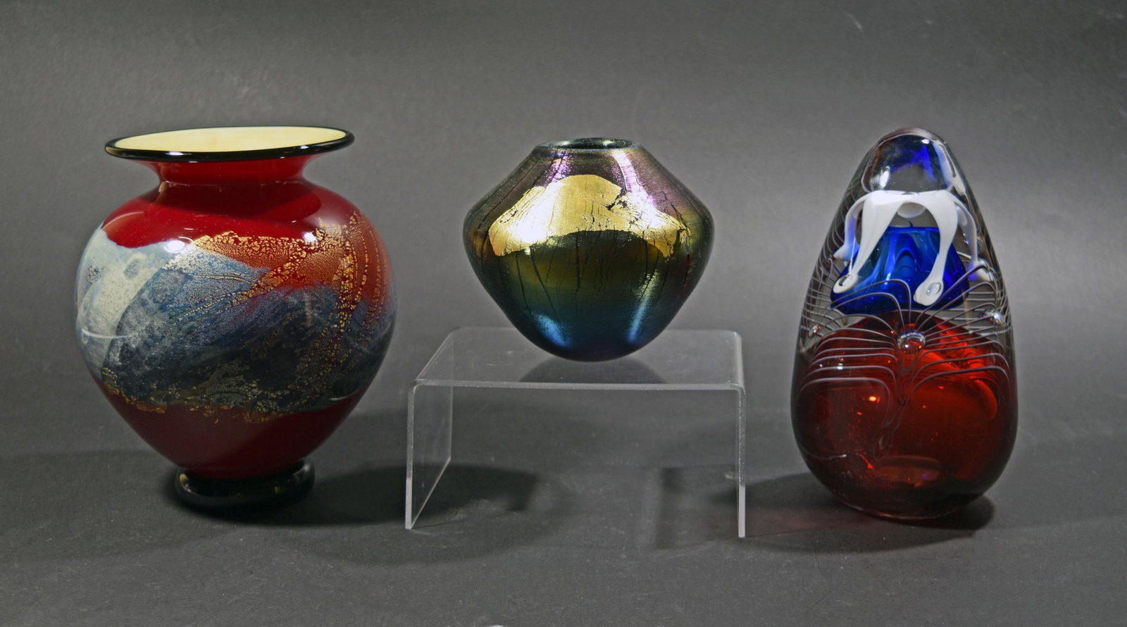 3 Studio Glass, Eickholt, Jablonski & Nourot: A group of studio art glass. Includes: a red, blue and gold bulbous vase by Michael Nourot, a small iridescent vase by Robert Eickholt, and a red, white, and blue paperweight by Adam Jablonski. Dimens
