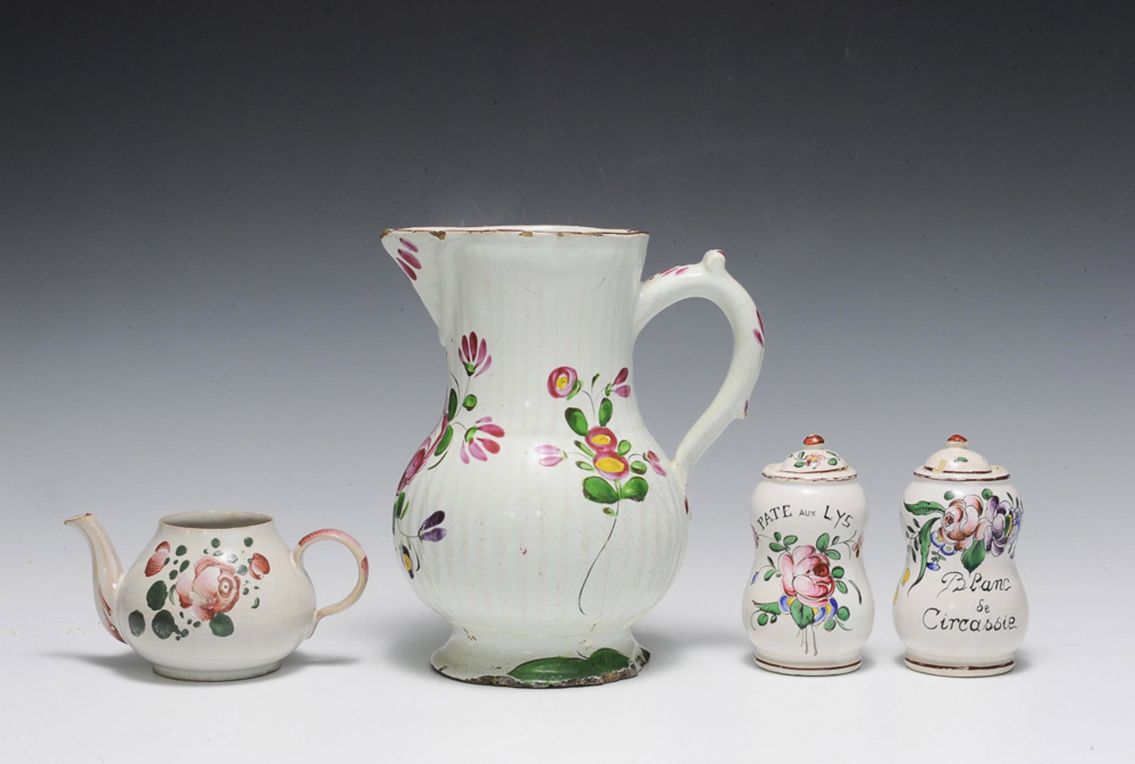 4 Luneville Faience Pitcher, Jars, Teapot, 18th Century: A group of 4 French faience Luneville pieces dating from the 18th century. Includes: a fluted pitcher featuring multi-colored flowers with a red trim, a pair of ointment/herb jars with lids, a small t