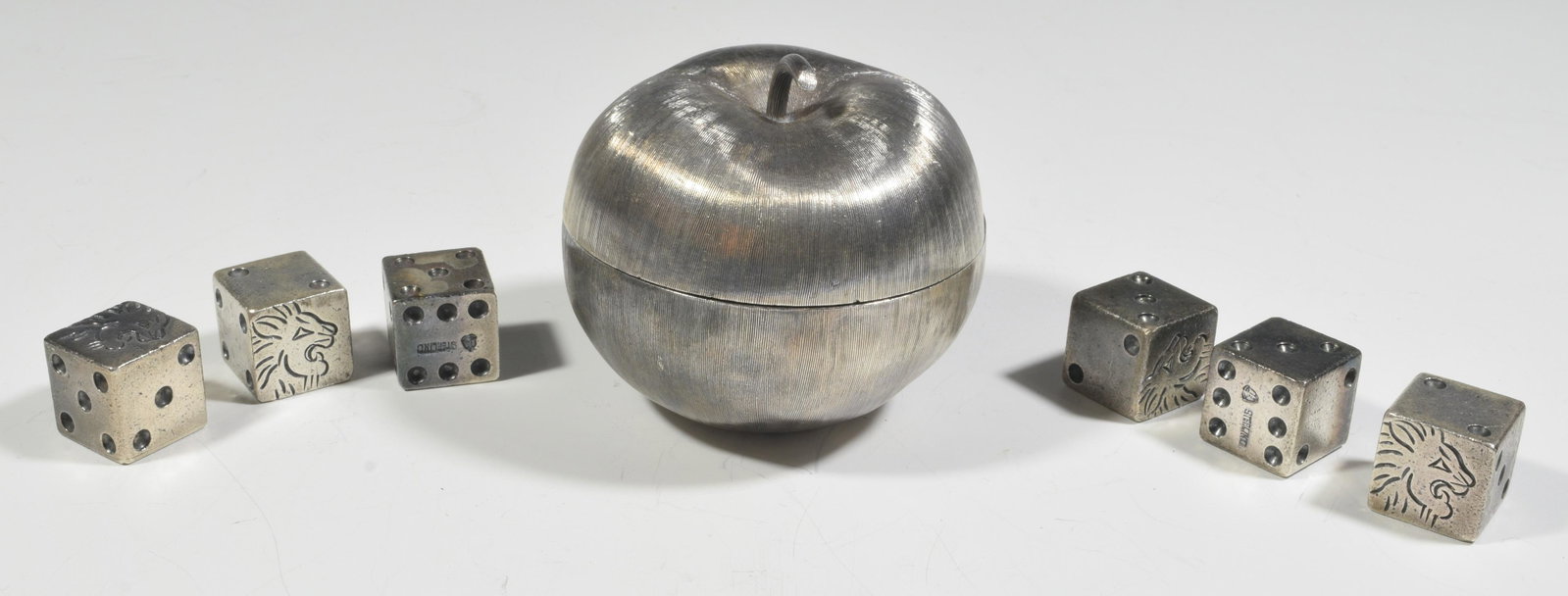 7 Mexican Sterling Silver Dice & Apple: Mexican sterling silver apple form trinket box, marked inside 'sterling, Mexico, Janna [sic]'. Six dice with the Eagle assay mark used from 1948-1955, the one side of eanh die engraved with a lion hea