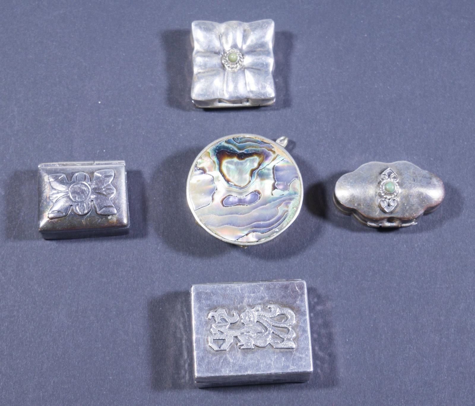 5 Latin American, Sterling Silver Pillboxes: 5 Latin American sterling silver pill boxes with decoration on the lids. One is marked from Guatemala, two are marked from Mexico, two are not marked with a place of origin, all are marked silver. Dim