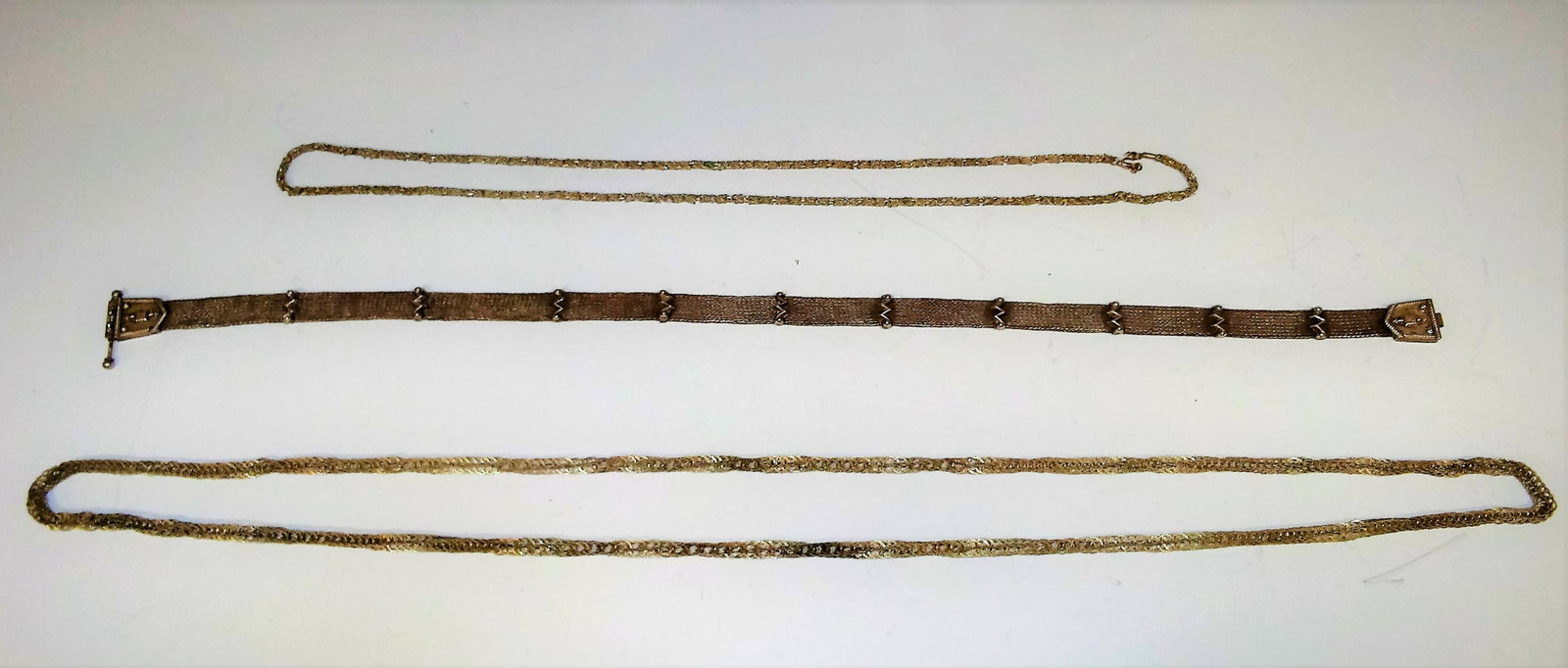 1 Sterling Silver Belt & 2 Silver-Tone Chains: An unmarked, but tested 925 sterling silver Indonesian belt. A necklace with silver-toned chains and a gold and silver metal necklace. Dimensions of largest: 64 1/2 inches long; 163.8 cm long. 203.9 g