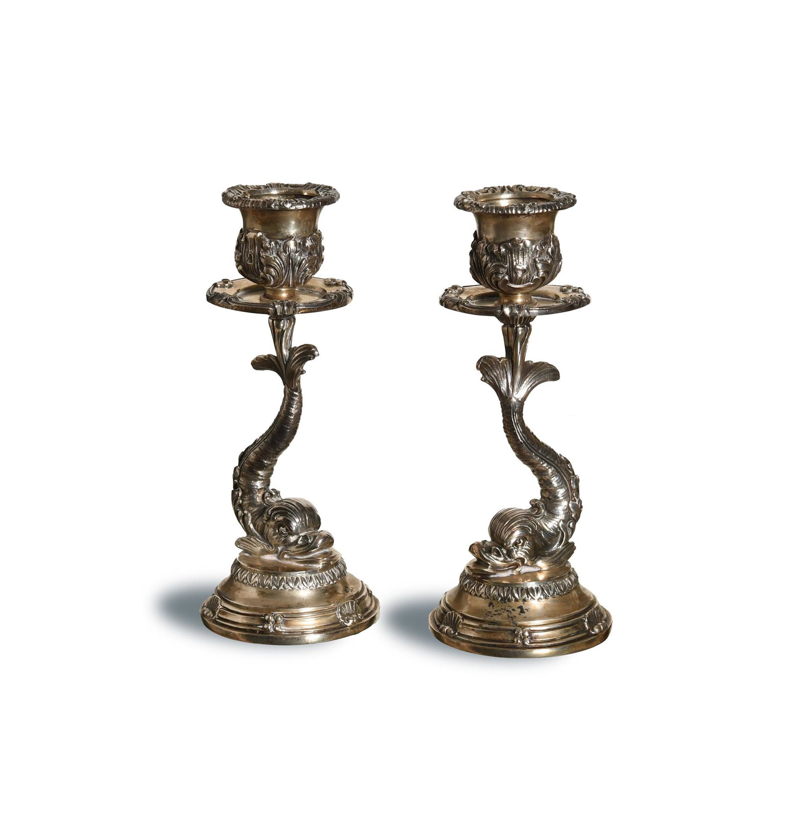 Buccellati, Sterling Silver Dolphin Candlesticks: Buccellati (Italian, 1919) sterling silver. Both of the candlesticks feature oak and clam shell motifs; the main stems are stylized dolphins supporting the candle sconces. It is marked with the compan
