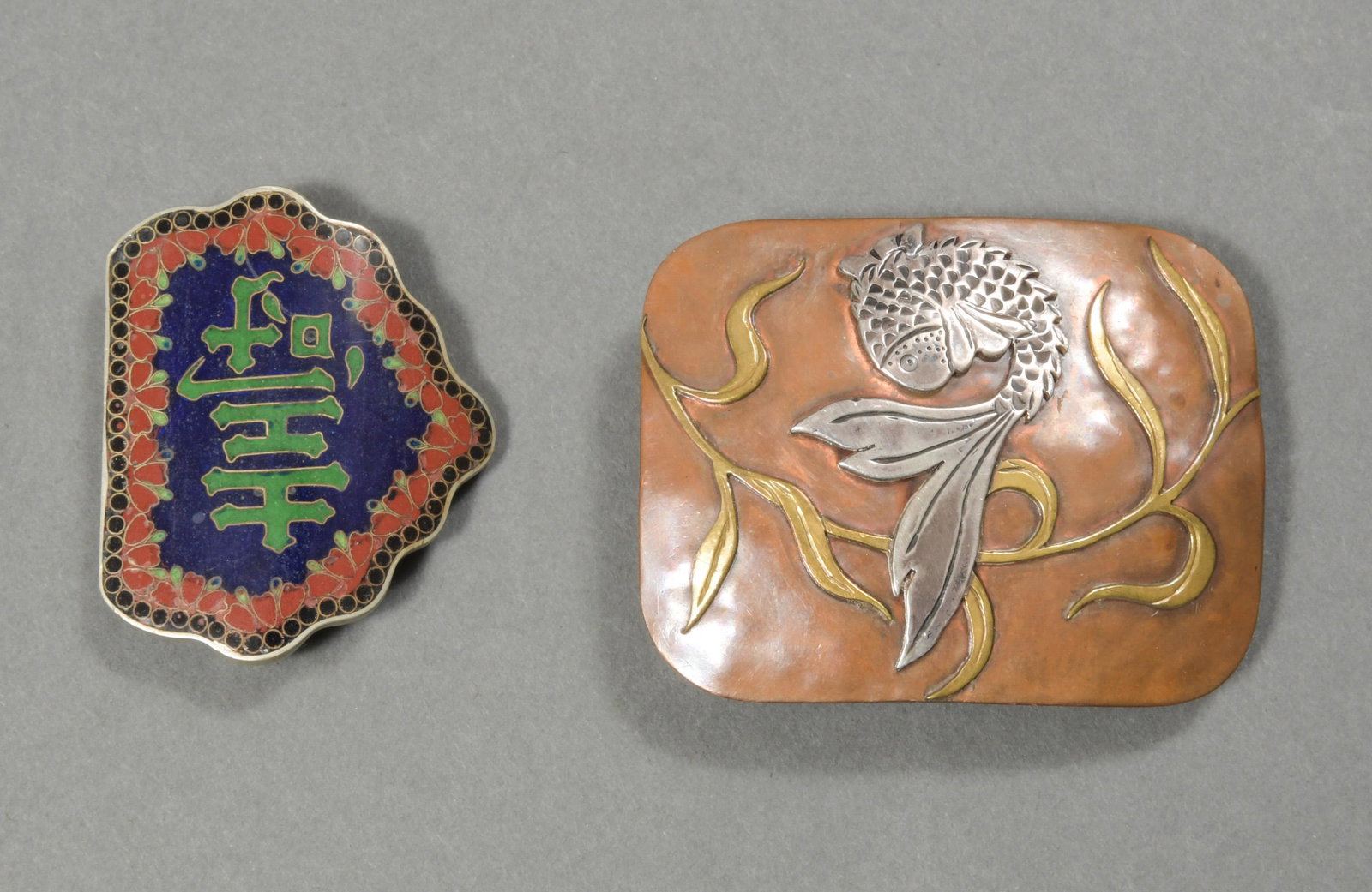 2 Mixed Metal Belt Buckles, Chinese & Japanese: Copper, bronze & silver buckle featuring a fish and an enameled buckle featuring a character, it is also signed 'Raya 78' on the back. Dimensions: 1 3/4 inches tall X 2 1/2 inches wide; 4.4 cm tall X 