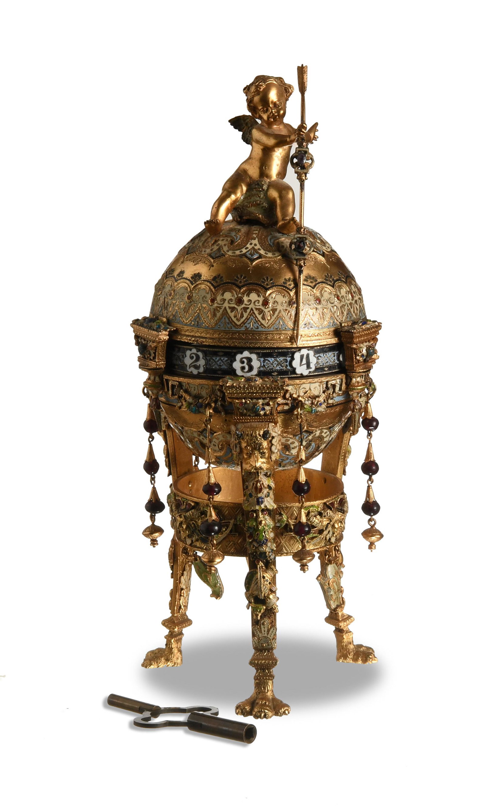 Gilt & Enamel Annular Dial Clock: Unmarked (probably French) mixed materials. A gilt and enamel decorated annular clock with various hanging decoration. The top of the clock features a cupid holding a staff. This piece includes a key.