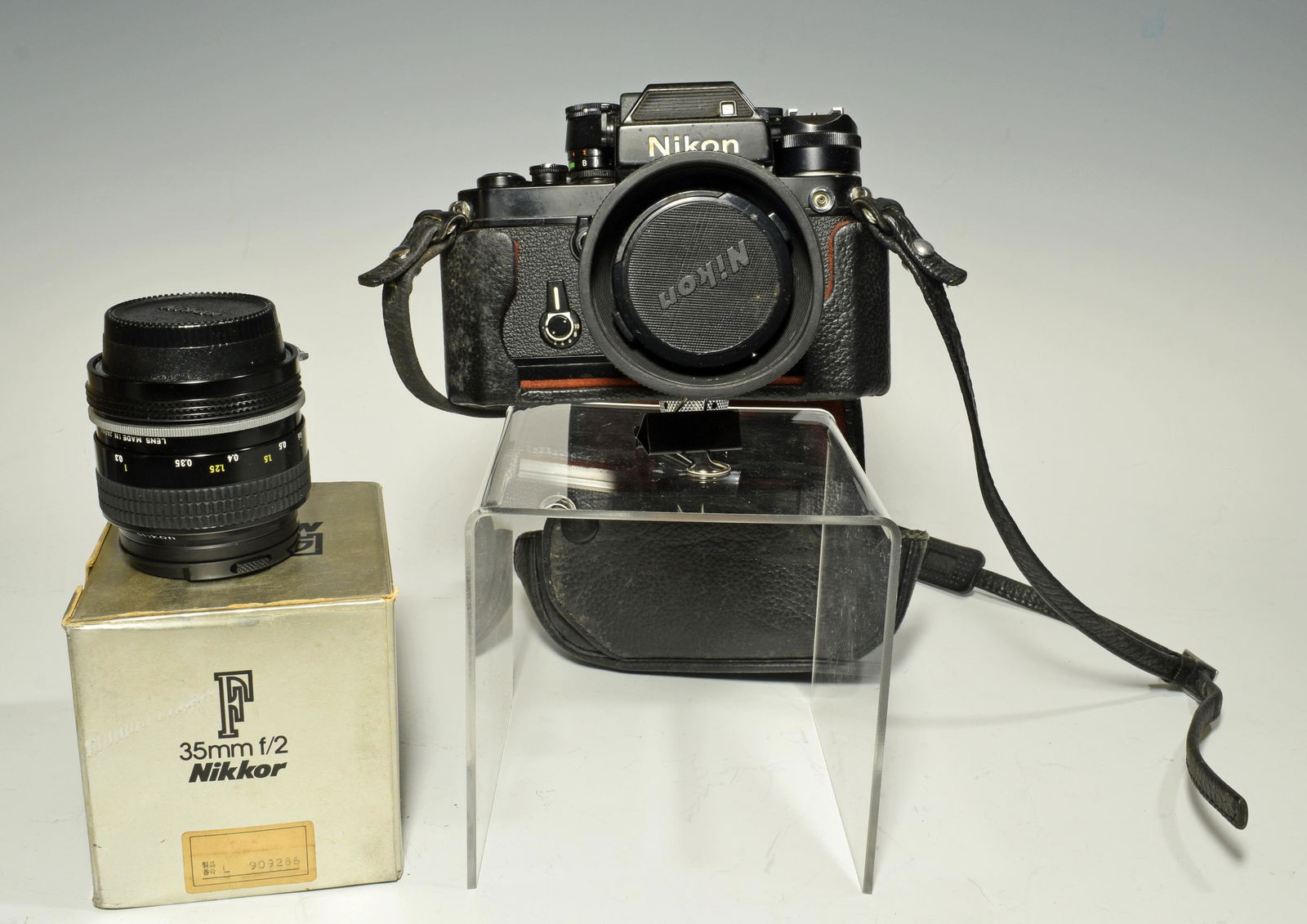 Nikon F2 with 35 & 50 mm Lenses: A Nikon camera with 35mm and 50mm lenses. The camera is serial no. 7731799, in production between 2/77 and 5/77. Includes a case with a strap. Dimensions: 5 inches tall X 6 1/4 inches wide; 12.7 cm ta