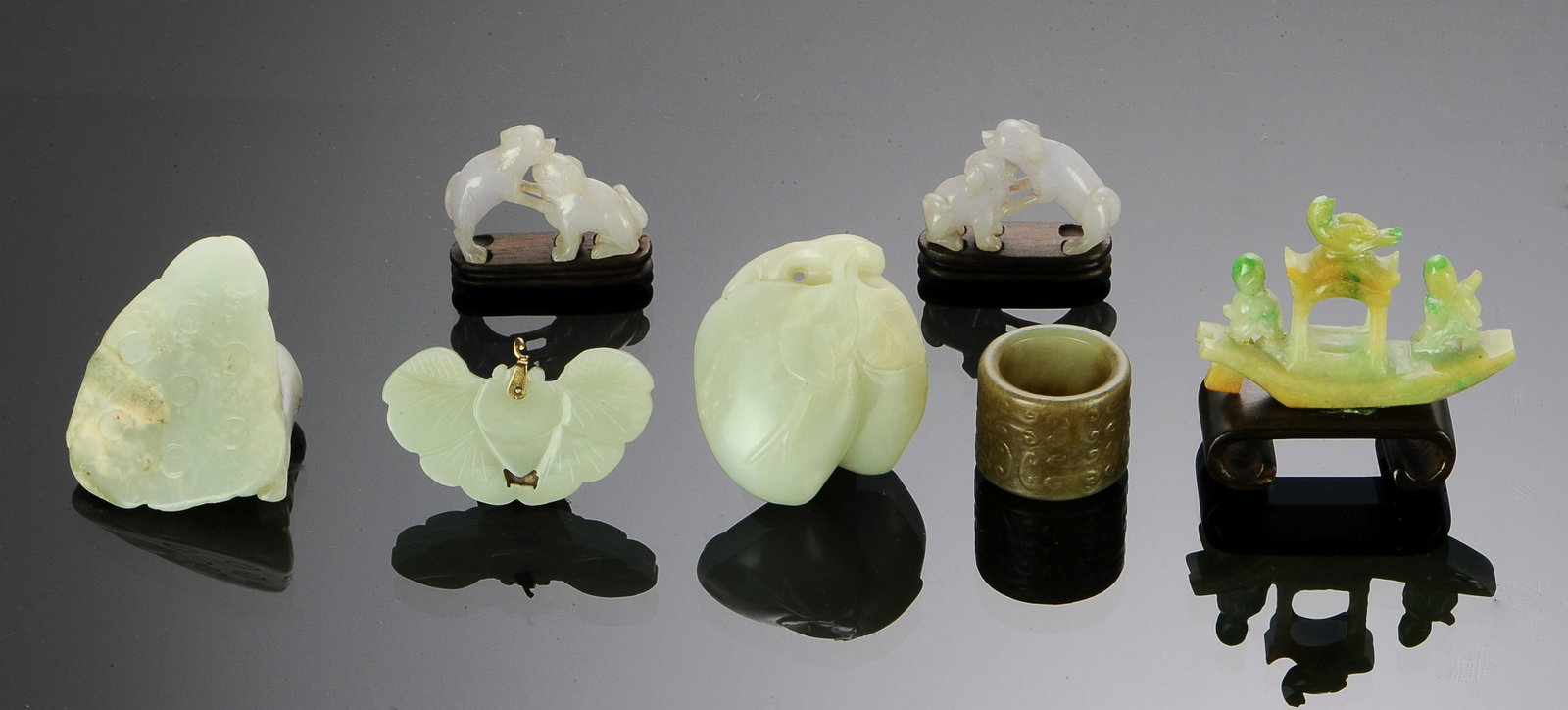 7 Chinese Jade & Jadeite Carvings, 18th-Republic: A group of 7 jade and jadeite carvings dating from the 18th century to the Republic period. Includes: a butterfly pendant, a jadeite boat, a white jade toggle featuring peaches, a carving of a lotus s