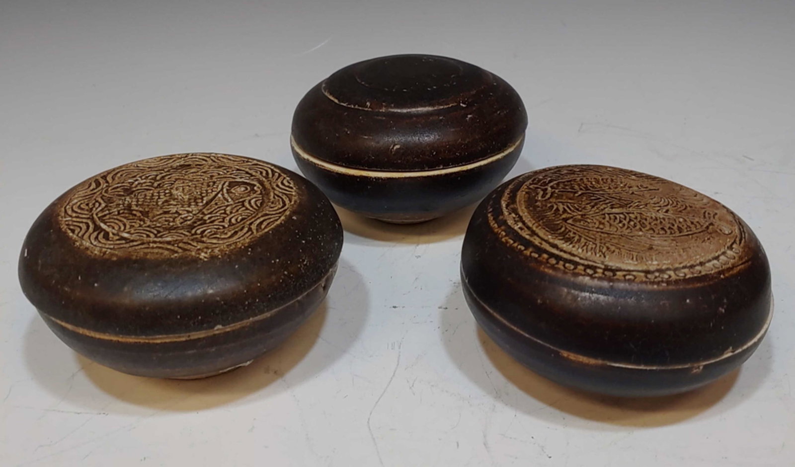 3 Vietnamese Shipwreck Ceramic Boxes, 15th Century: 3 Chinese export ceramic powder boxes, dating to the 15th century, found and excavated in a shipwreck off the coast of Quang Ngai, Vietnam. Includes a round brown powder box impressed with the image o