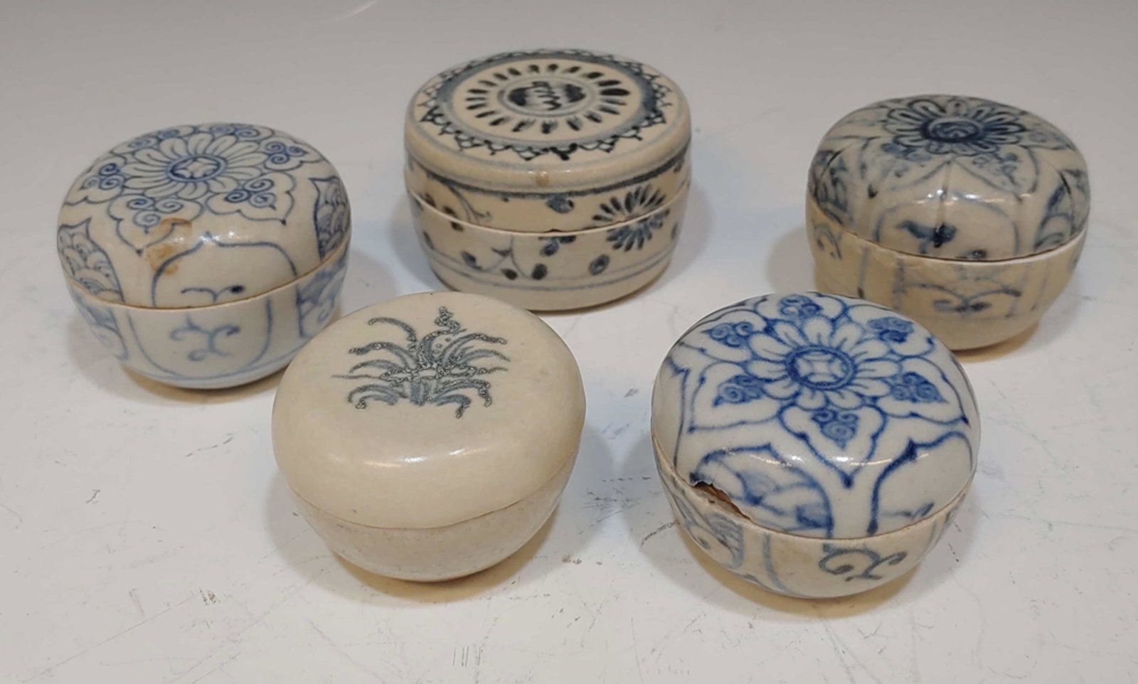 5 Vietnamese Shipwreck Jarlets: 5 Chinese export porcelain jarlets, retrieved from a shipwreck off the coast of Vietnam. Includes 3 blue and white jarlets with lids featuring flower designs, a blue and white jarlet with a lid and fl