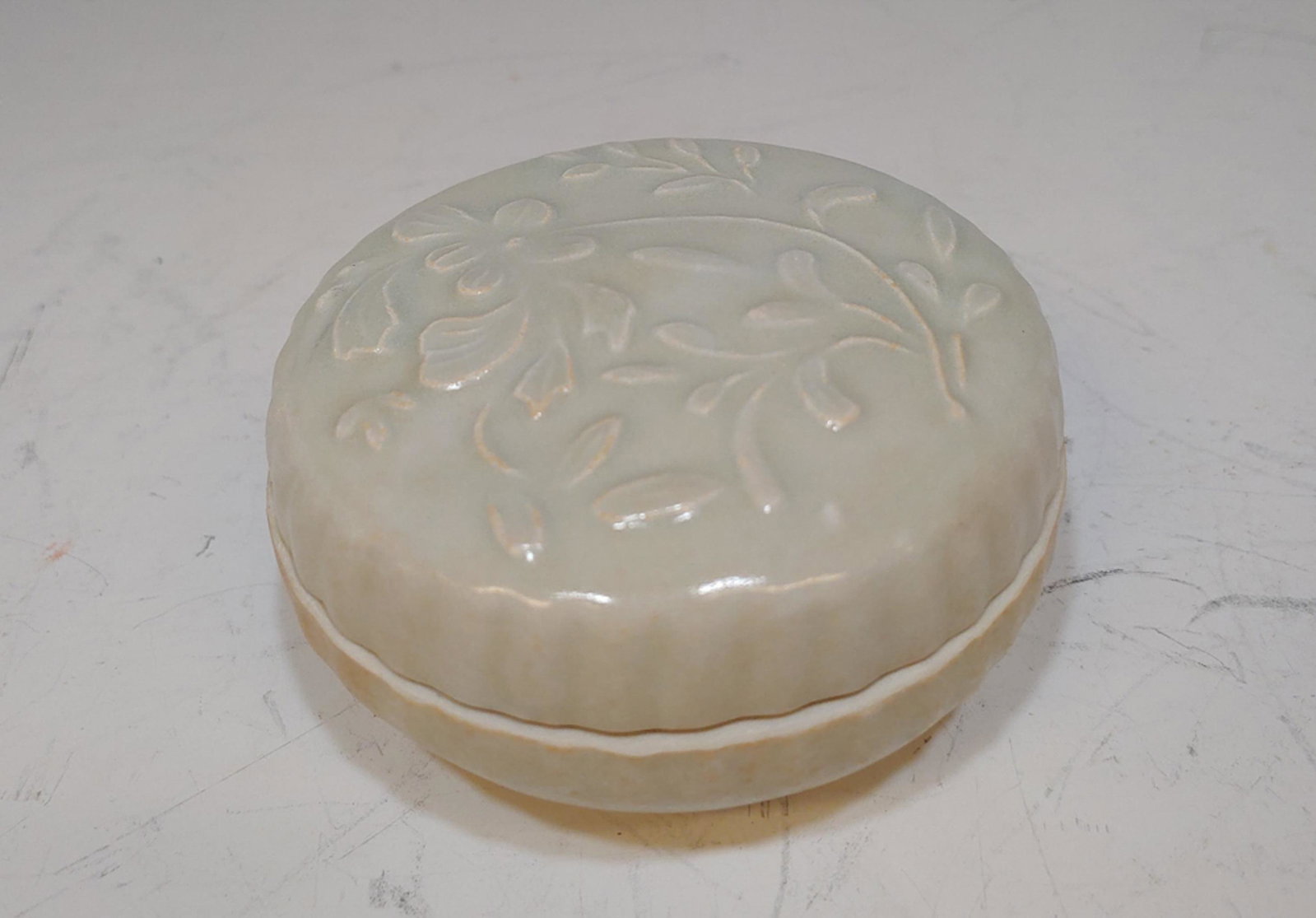 Vietnamese Shipwreck Porcelain Ink Box: A Vietnamese shipwreck ceramic ink box, dating to the Sung or Yuan dynasties. The lid features a flower design, the sides of the lid and base feature fluting. Dimensions: 1 1/2 inches tall X 4 inches 