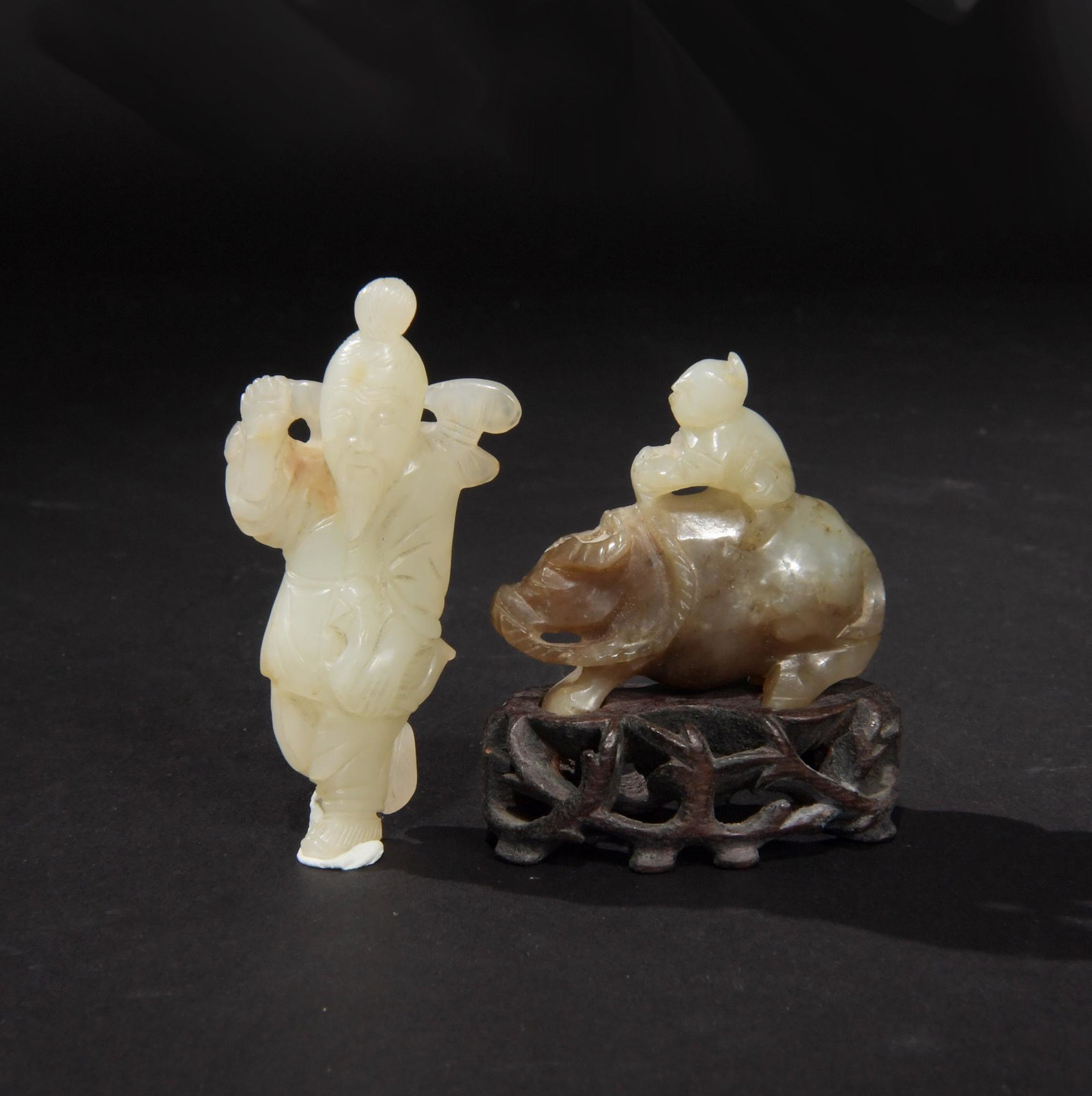 l2 Chinese Jade Carvings of Figures, Ming to Qing: A group of 2 jade carvings dating from the Ming to the Qing dynasty. The group includes: a boy on a water buffalo, with a wood stand and an old man holding a lingzhi and a goose. Dimensions are: carvi