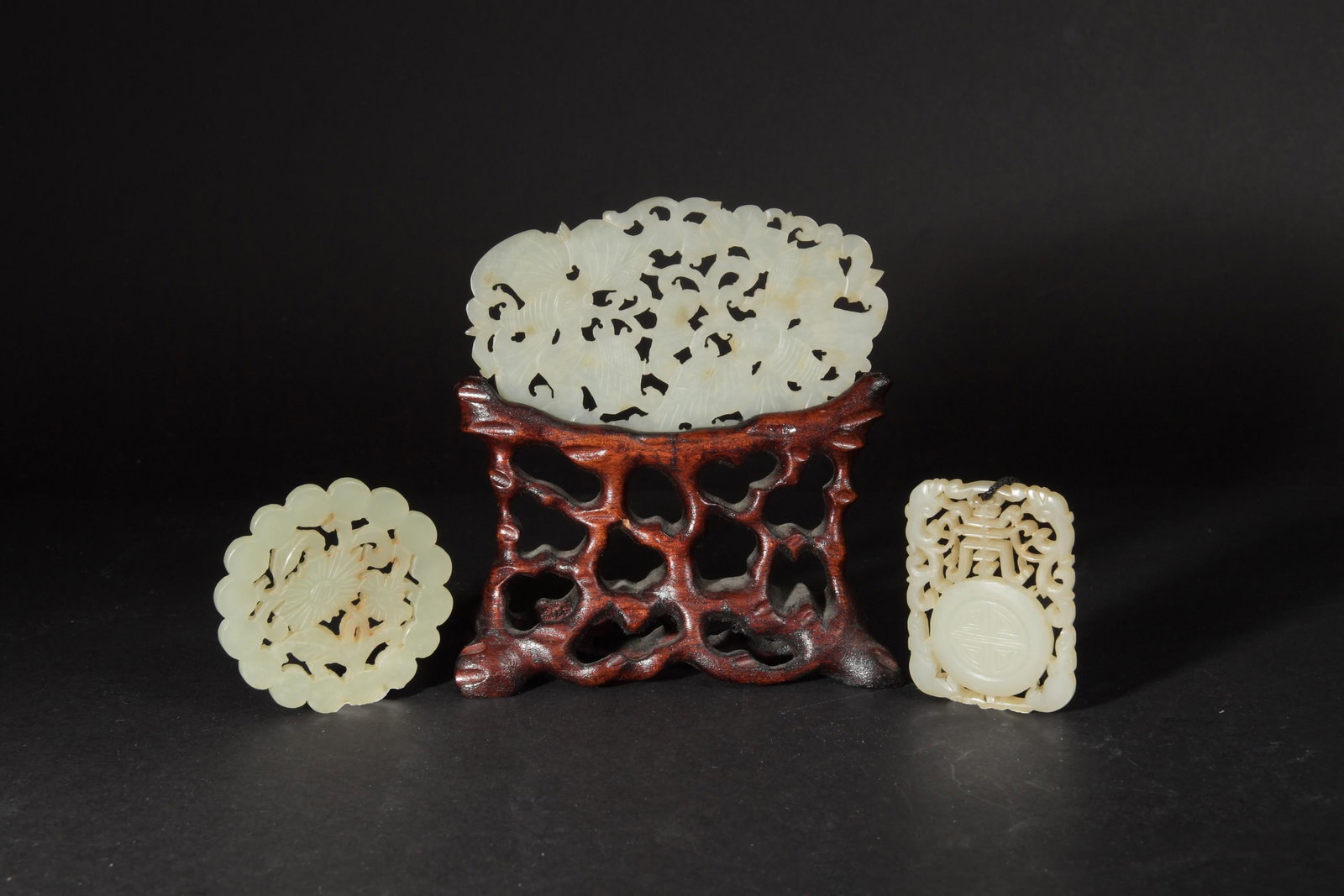 Group of 3 Pierced Jade Plaques, 18-19th Century: A group of 3 Chinese pierced jade plaques dating from the 18th to the 19th century. The group includes: a rectangular pierced plaque featuring a Shou character, pair of dragons, and a Shou medallion; 