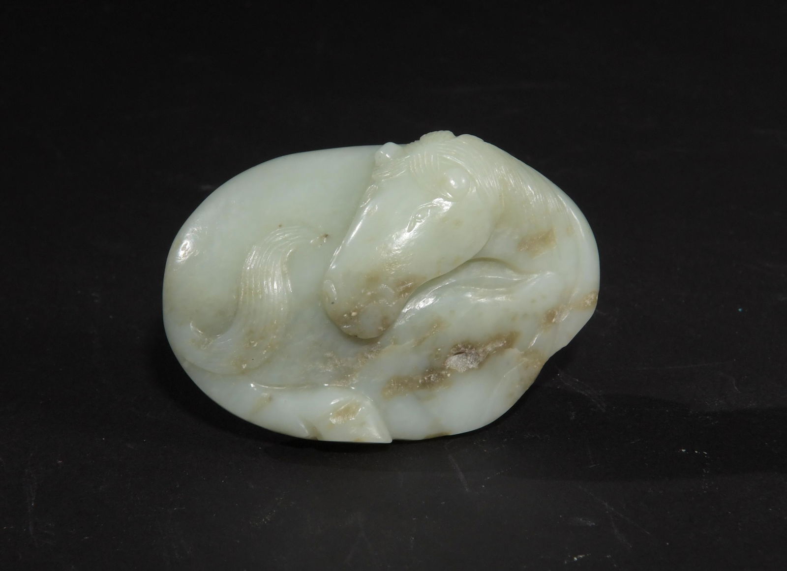 Chinese Jade Horse Belt Buckle, Ming Dynasty: A Chinese jade belt buckle featuring a horse dating from the Ming dynasty. Dimensions are: 2 7/8 inches tall X 2 inches wide; 7.3 cm tall X 5.1 cm. All measurements are approximate. Condition: Large c