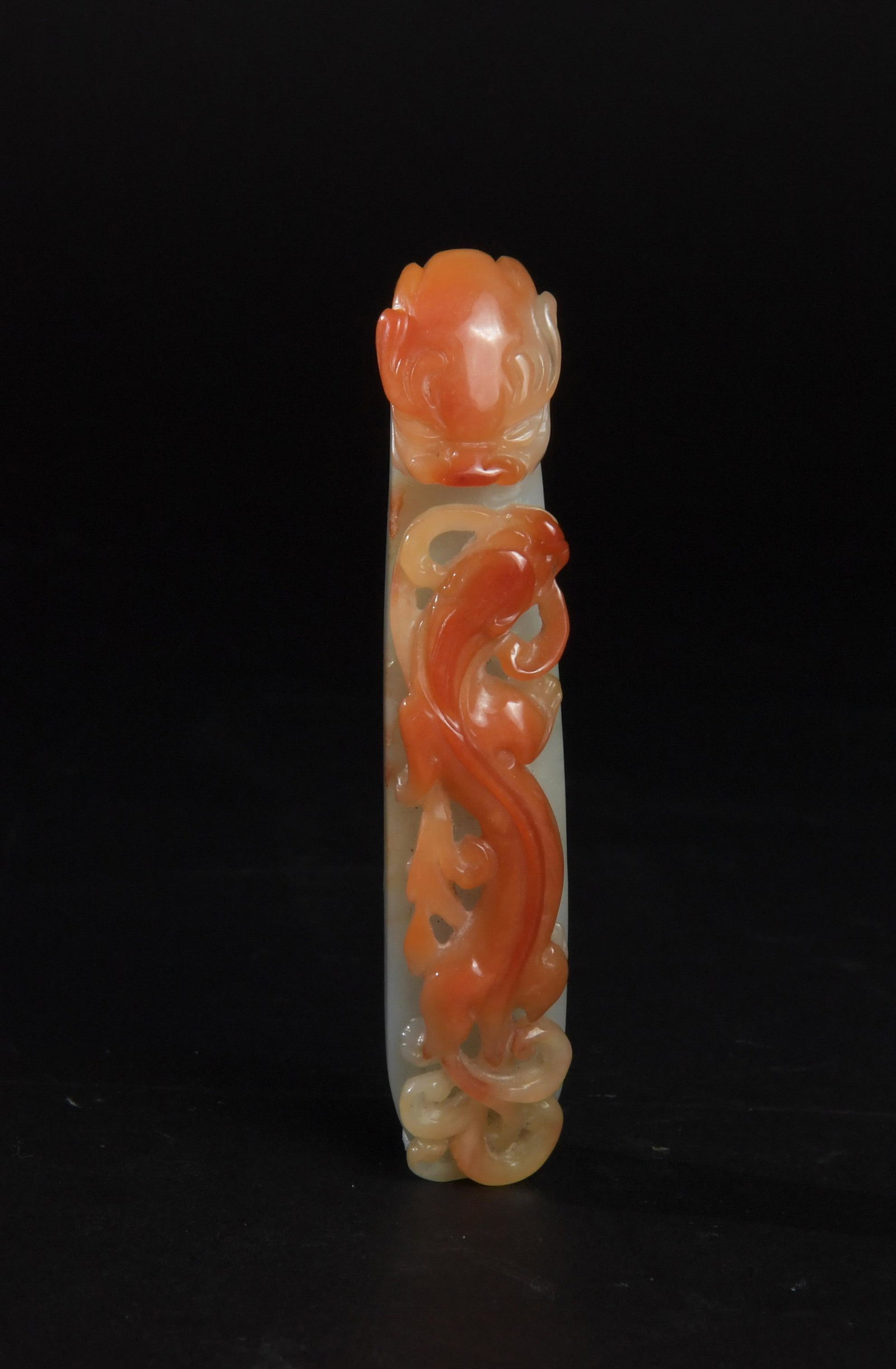 Chinese Red Jadeite Dragon Hook, 19th Century: A Chinese red jadeite dragon hook featuring a chilong and dating from the 19th century. Dimensions: 3 5/8 inches tall X 3/4 inch wide; 9.2 cm tall X 1.9 cm wide. All measurements are approximate. Cond