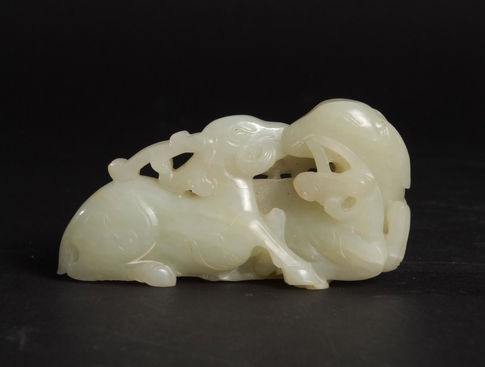 Chinese White Jade Carving of 2 Deer, 18th Century: A Chinese white jade carving dating from the 18th century and featuring 2 deer eating lingzhi. Dimensions: 1 1/2 inches tall X 3 1/4 inches wide; 3.8 cm tall X 8.3 cm wide. All measurements are approx
