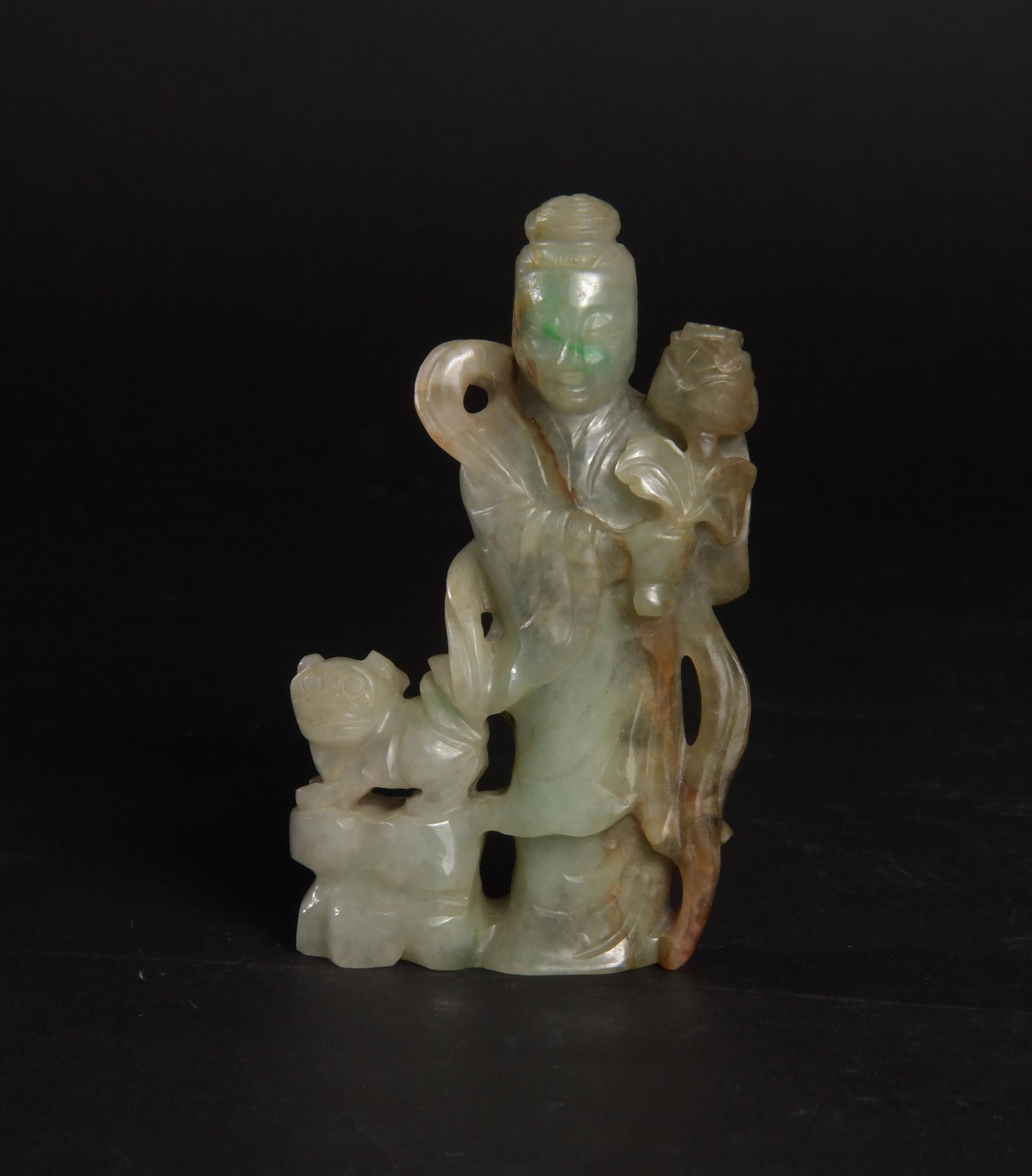 Chinese Jadeite Statuette of a Lady, 19th Century: A Chinese jadeite with skin statuette dating from the 19th century. The statuette depicts a lady holding a flower and accompanied by a lion. Dimensions: 4 1/2 inches tall X 2 1/2 inches wide; 11.4 cm 