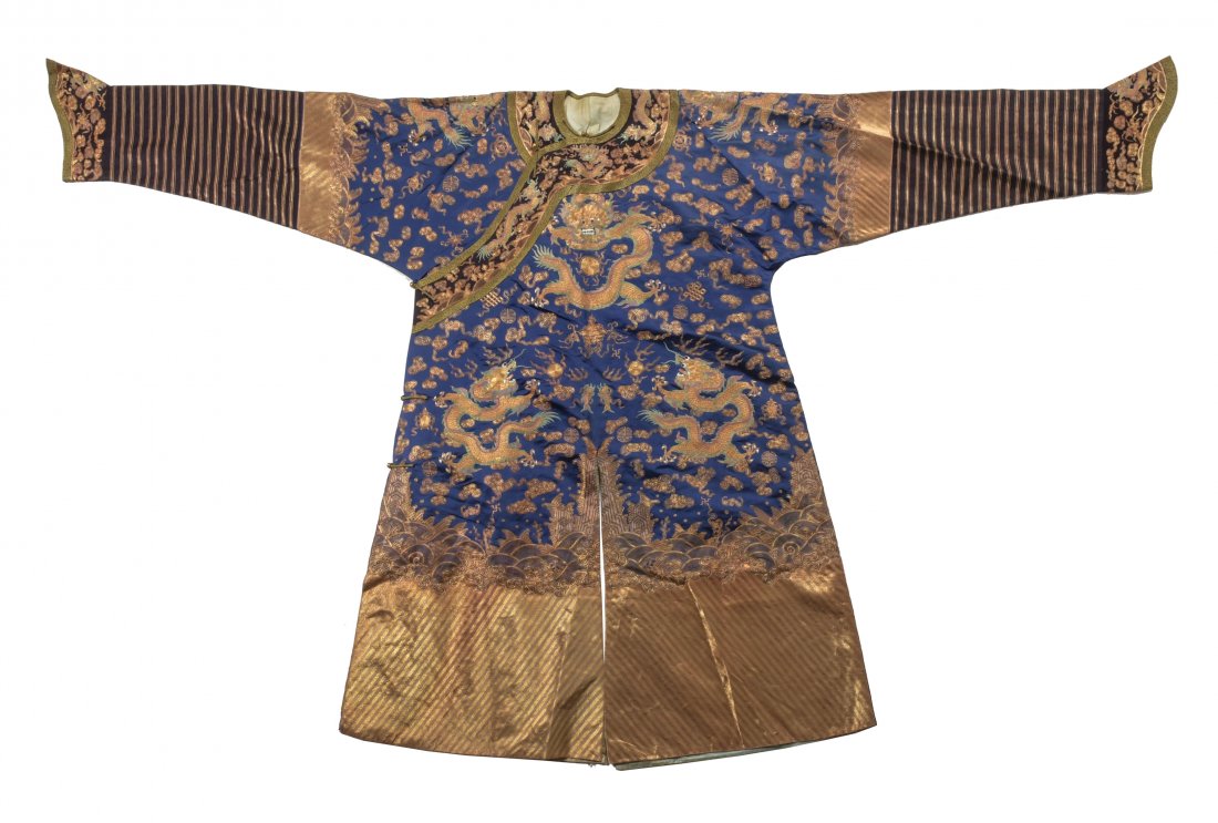 Chinese Blue Ground Dragon Robe, 19th Century: A Chinese blue ground dragon robe dating from the 19th century. The robe features 8 dragons, 1 secret dragon panel, the 8 Buddhist emblems, the wave and rock motif, bats and Shou medallions. Dimension