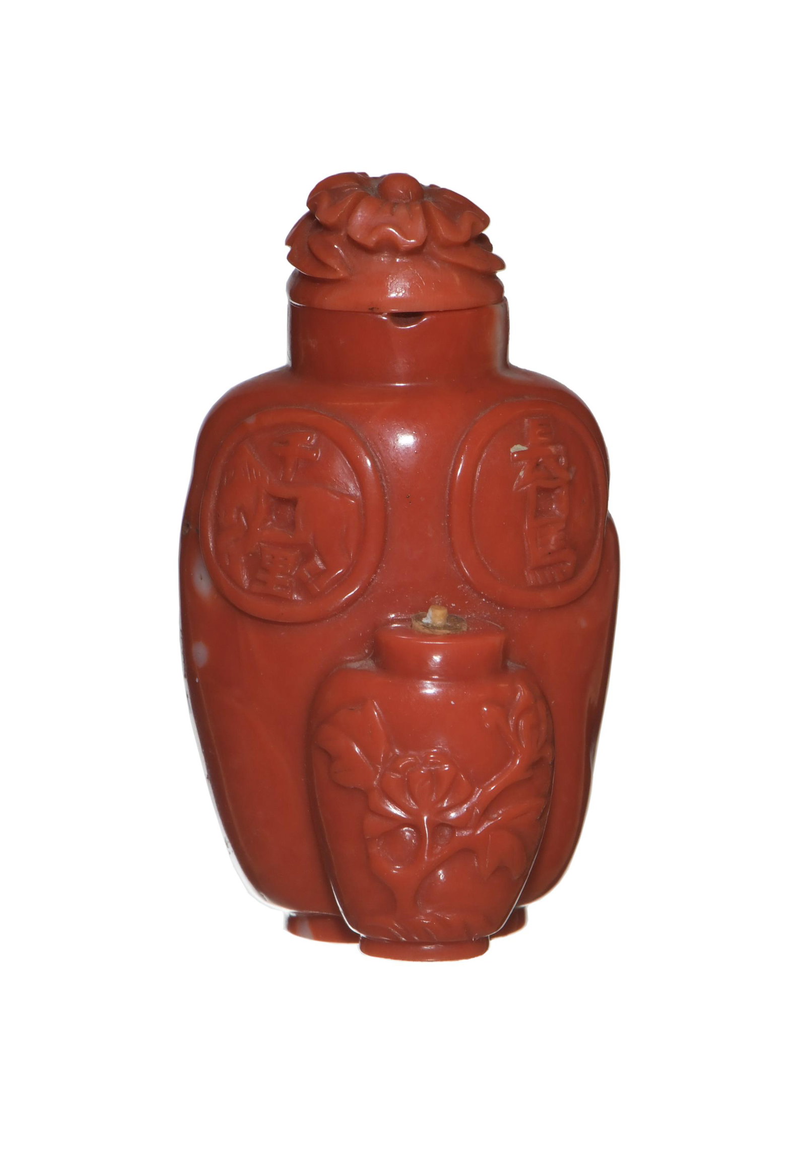 Chinese Coral Carved Snuff Bottle, 19th Century: A Chinese carved coral snuff bottle dating from the 19th century. The snuff bottle features flowers in a vase; two lucky coins; a dog; and two stylized pennant shapes with 2 characters. The snuff bott