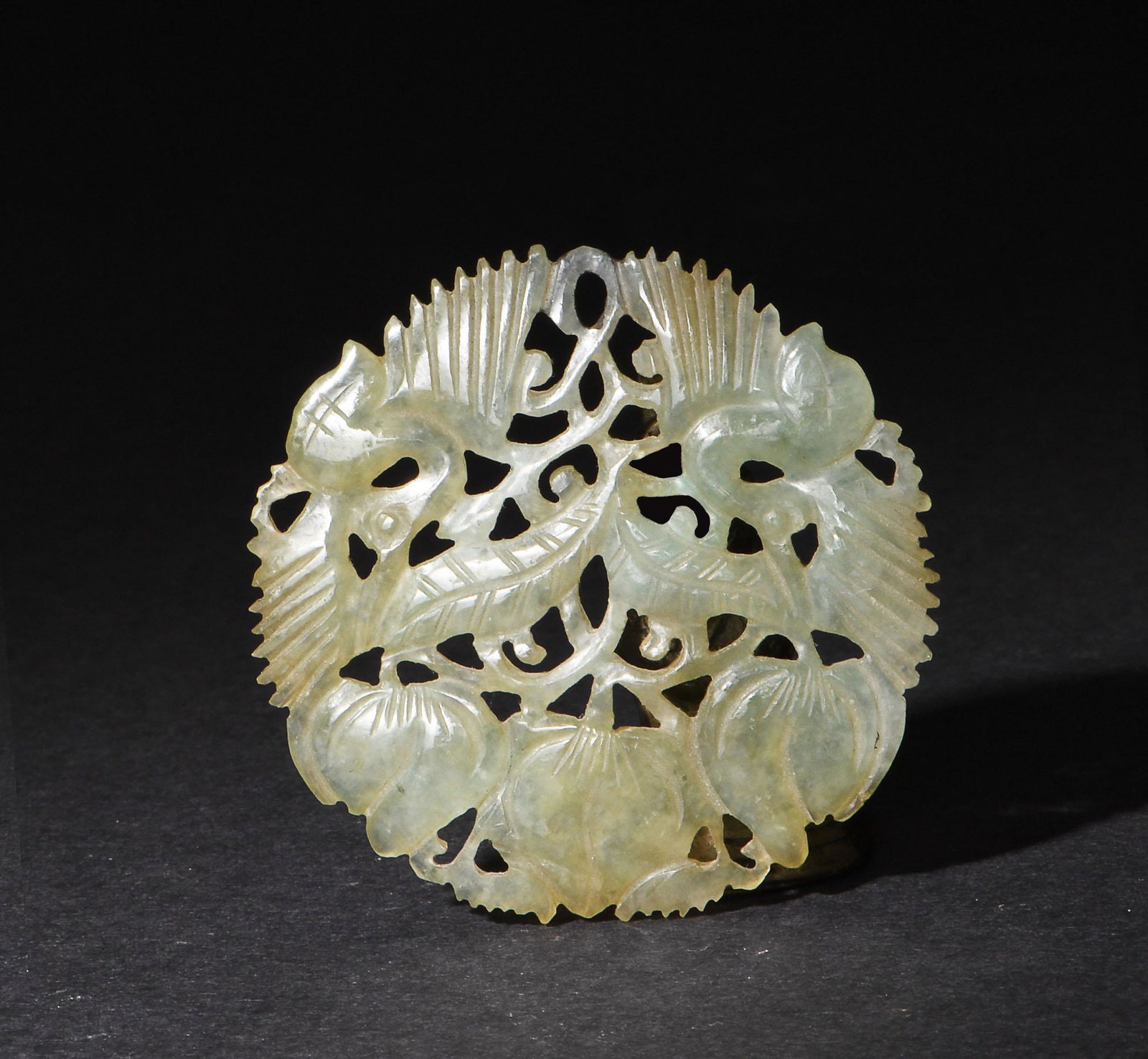 Chinese Round Jadeite Cutout Plaque, 19th Century: A Chinese circular jadeite cutout plaque featuring a pair of peaches and a pair of cranes, dating from the 19th century. Dimensions: 1/8 inches tall X 2 inches wide; 0.3 cm tall X 5.1 cm wide. All mea