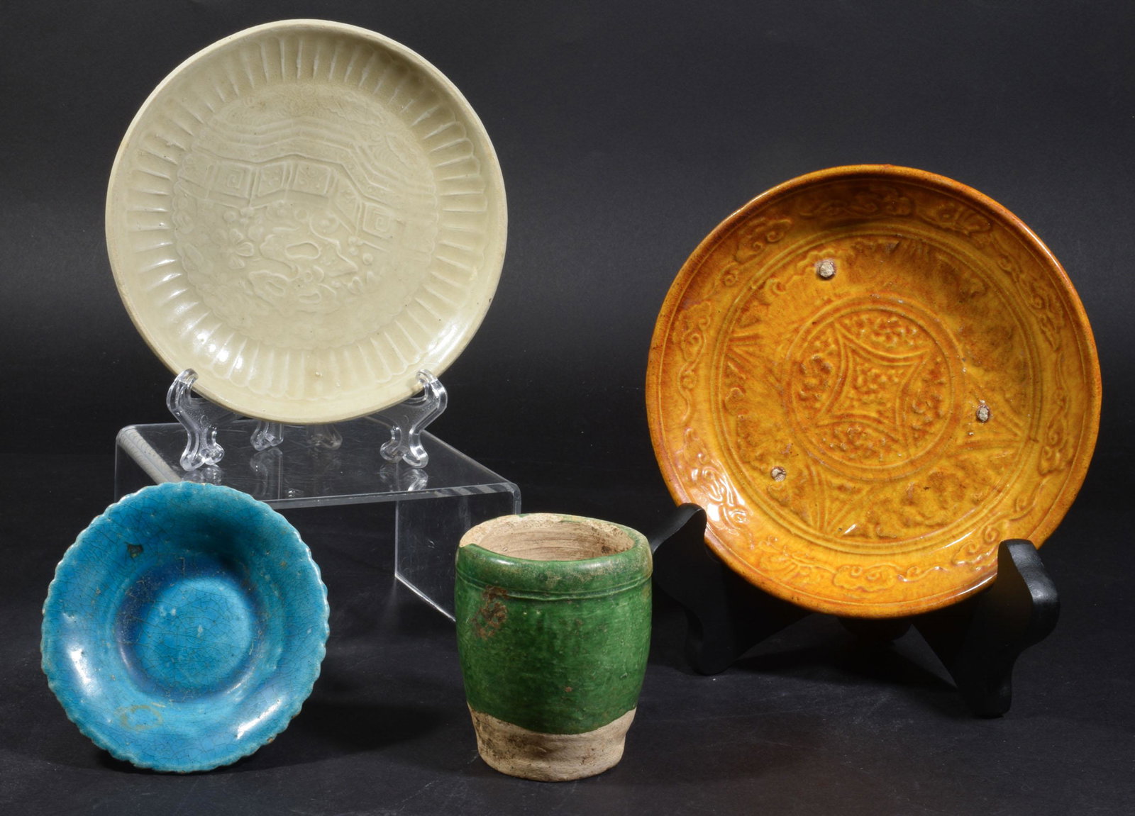 4 Glazed Plates and Cup, Han or Song Dynasty: A group of 4 Chinese porcelain items dating from the Han or Song dynasty. Includes 3 glazed plates and 1 partially glazed cup. Small blue glazed plate with floral underside. Beige plate with bridge sc