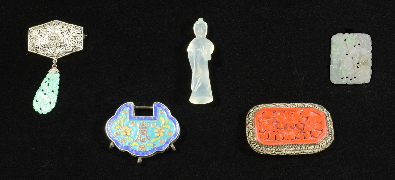 5 Chinese Jewelry Pieces: A group of 5 Chinese jewelry pieces. Includes a carved white and green jade plaque featuring flower blossoms and peaches; a silver broach with a turquoise drop; a silver brooch with cinnabar inset; a 