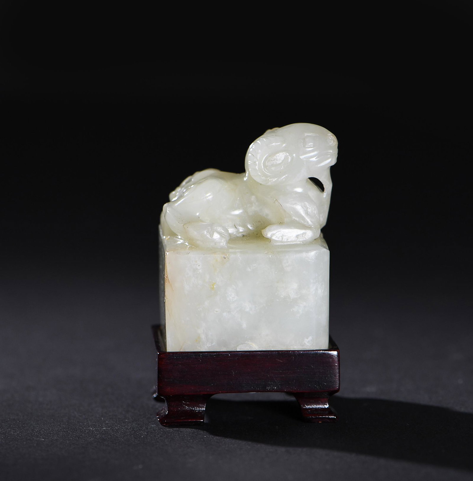 Chinese Jade Seal with Ram Finial, Ming: A Chinese jade blank square seal dating to the Ming dynasty. The seal includes a ram finial. It is accompanied by a wooden stand. Dimensions are: 2 inches tall X 1 1/2 inches wide, 5.1 cm tall X 3.8 c