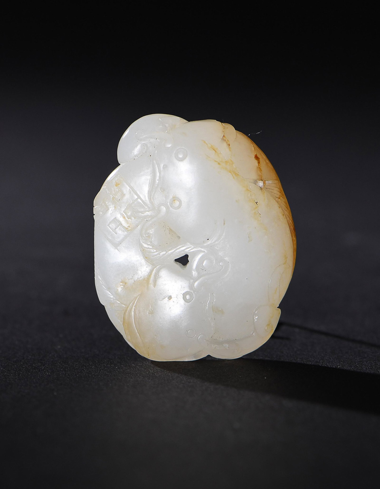 Chinese White Jade Carved Toggle, 18th Century: A Chinese white jade carved toggle dating to the 18th century. The toggle is showing two interlocking liyu with a Buddhist cross. Dimensions are: 1 1/2 in. tall X 1 1/4 in. wide; 3.8 cm tall X 3.2 cm 