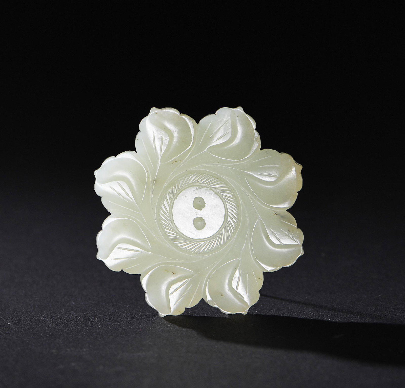 Chinese Jade Flower Plaque, Ming: A Chinese white jade flower shaped plaque, dating to the Ming dynasty. The plaque is carved with eight petals on one side, and 8 ruyi encircling a pair of dragons on the other side. Dimensions are 2 1