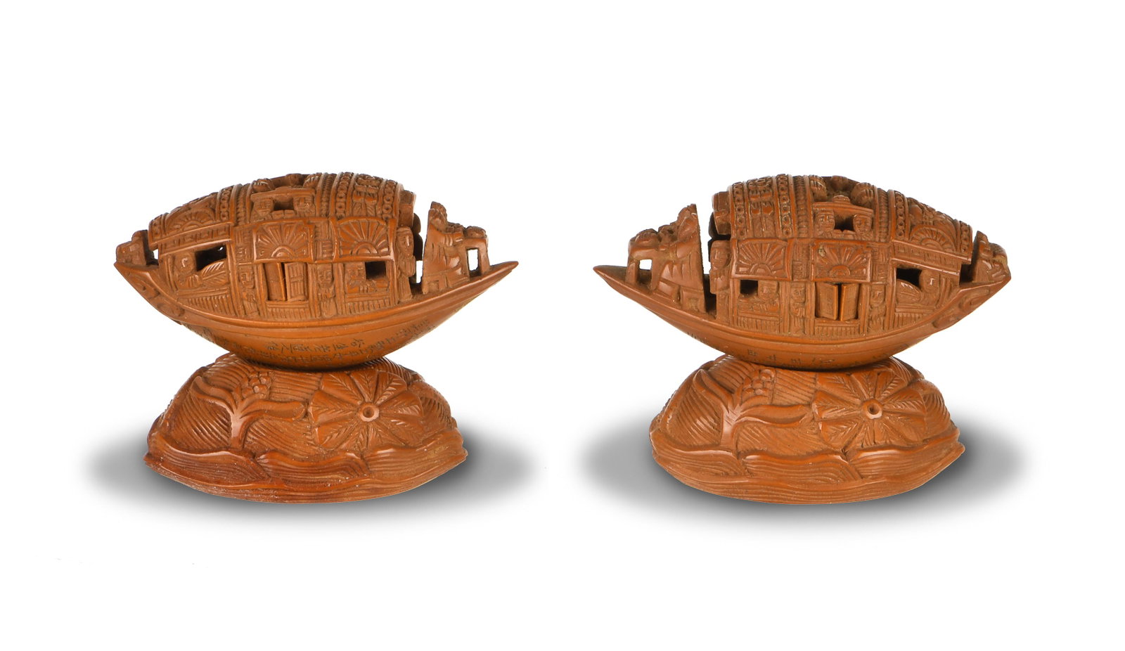 Pair of Chinese Carved Olive Pit Boats, 19th Century: A pair of Chinese olive pit carved boats and stands dating from the 19th century. Both feature an inscription and a pair of opening windows. Dimensions are: 3/4 inches tall X 1 5/8 inches wide, 1.9 cm