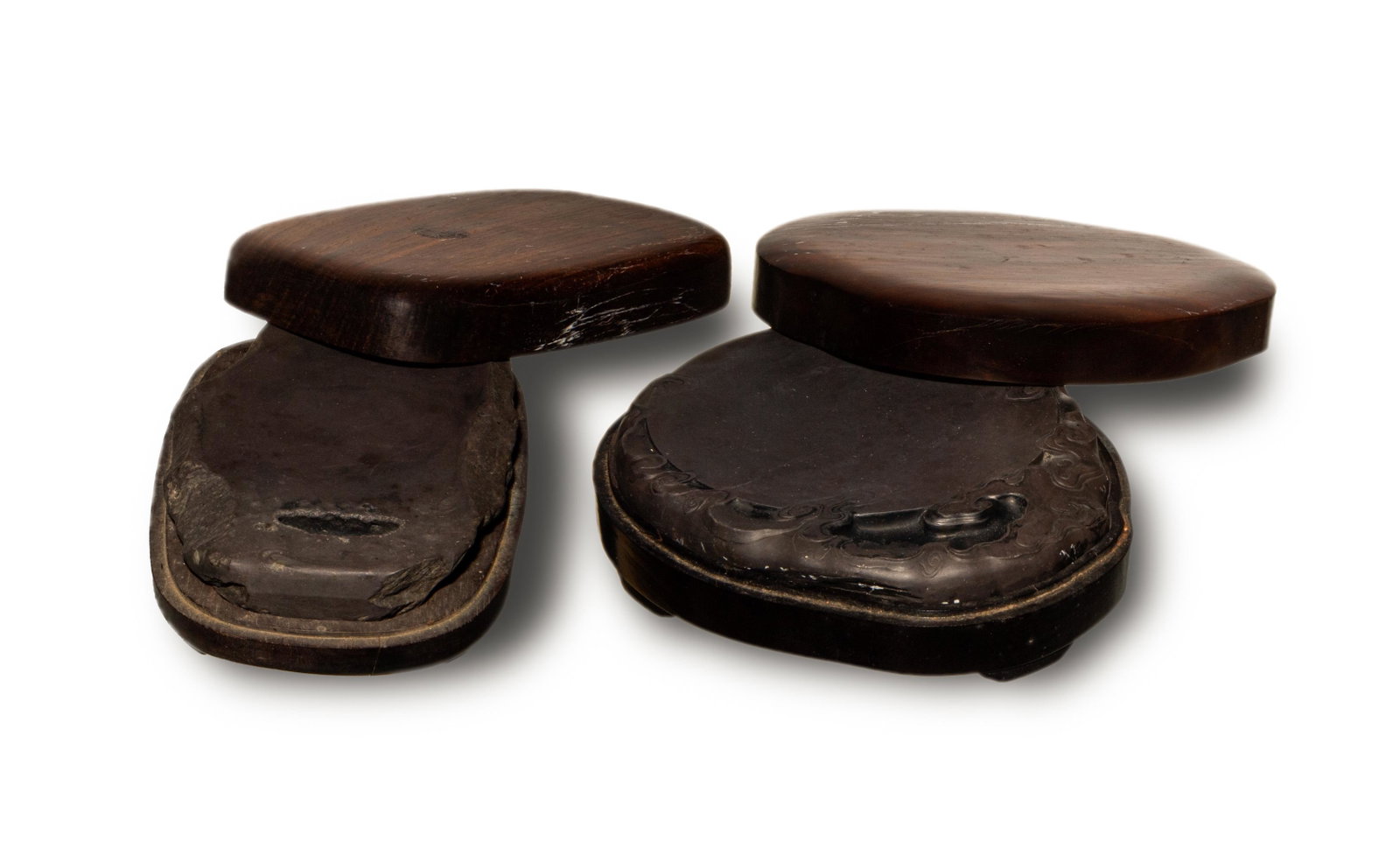 Two Chinese Duan Inkstones with Boxes, 19th Century: A Chinese pair of inkstones dating from the 19th century. The inkstones are accompanied by wooden cases. The stones are carved to show ruyi clouds and flower branch, respectively. Dimensions of the la