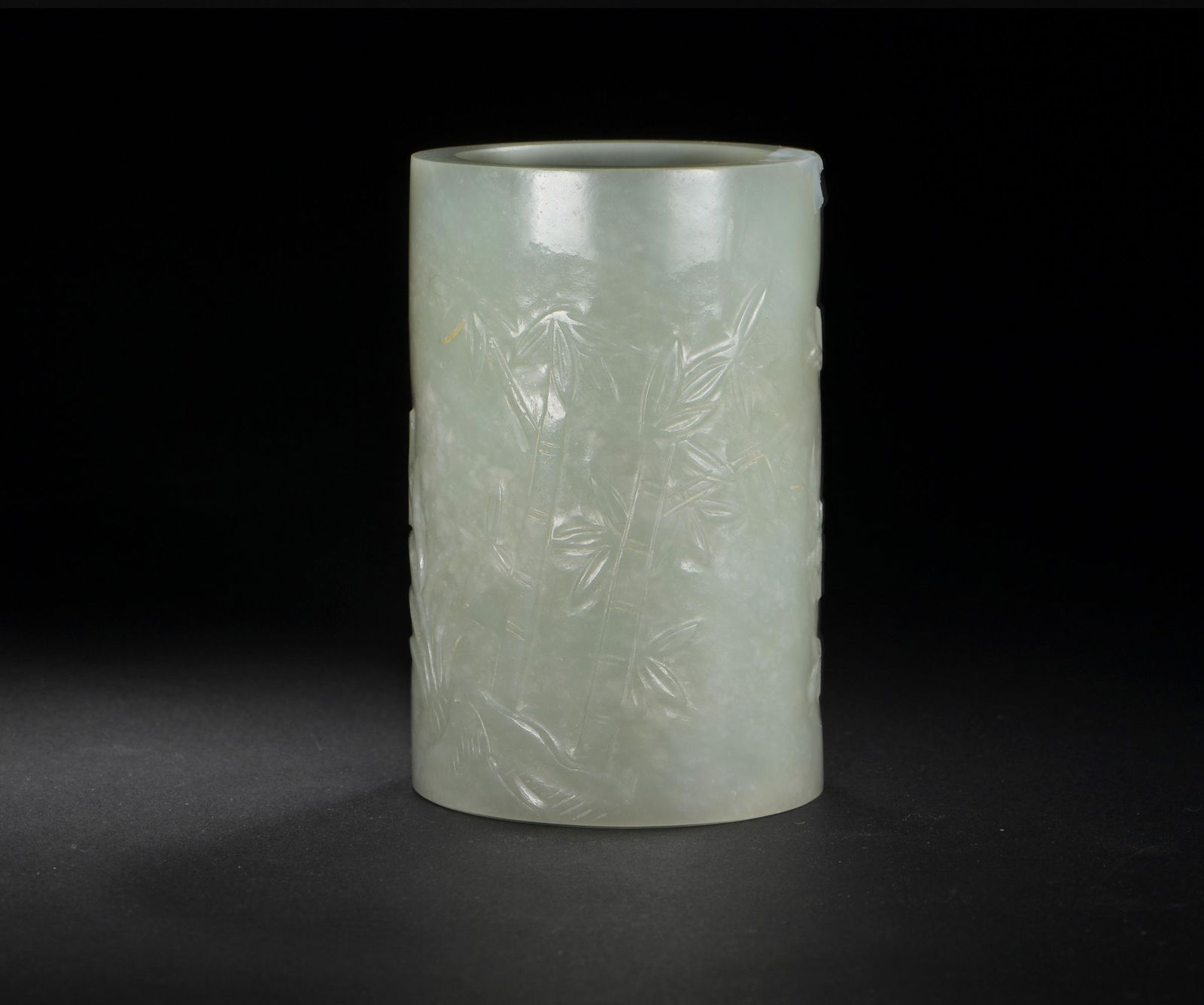 Chinese Jade Brushpot, 19th Century: A Chinese mutton fat jade carved brushpot dating from the 19th century. The brushpot features a low relief landscape. Dimensions: 3 1/2 inches tall X 2 1/4 inches wide; 8.9 cm tall X 5.7 cm wide. All
