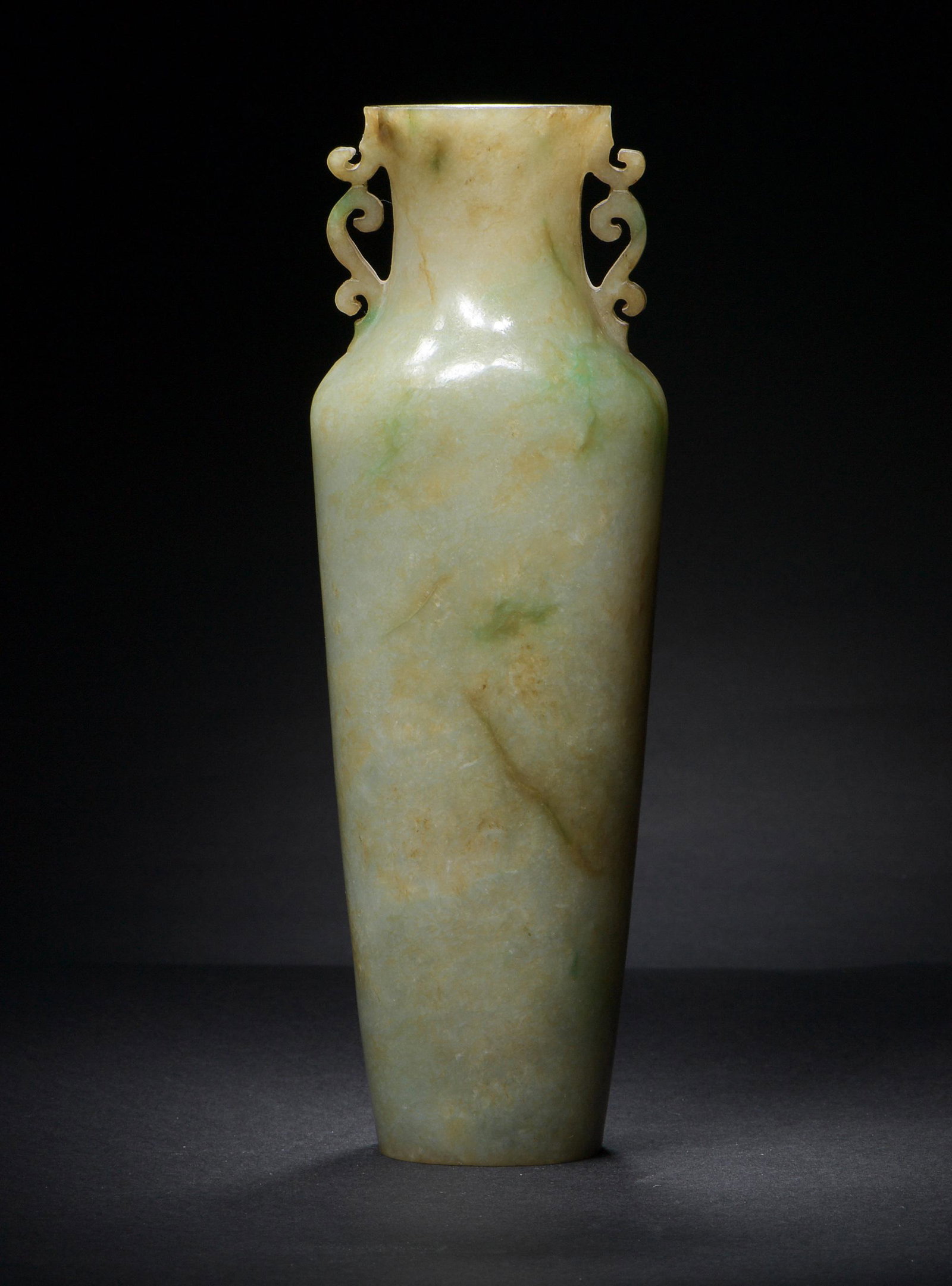 Chinese Jadeite Double Handle Vase, 19th Century: A Chinese jadeite vase dating from the 19th century. The vase has curled handles. Dimensions: 8 1/8 inches tall X 2 3/4 inches wide; 20.6 cm tall X 7 cm wide. All measurements are approximate. Conditi