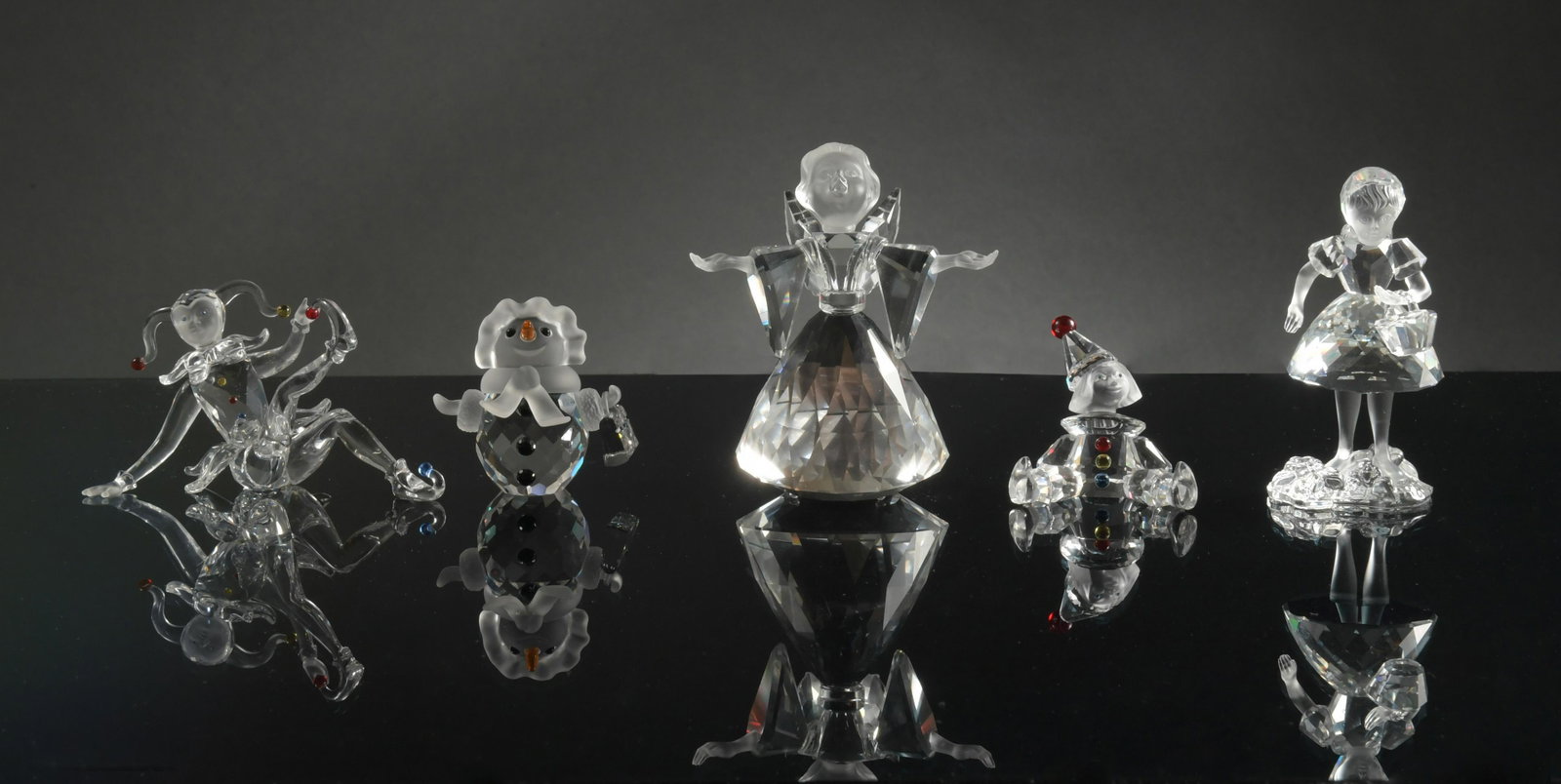Swarovski, 5 Boxed Figures, Angel, Jester Etc.: Swarovski (Austrian, founded 1895) crystal. A group of crystal figures including: a snow woman, an angel, a puppet, a jester, and little red riding hood. The figurines come in the original boxes with 