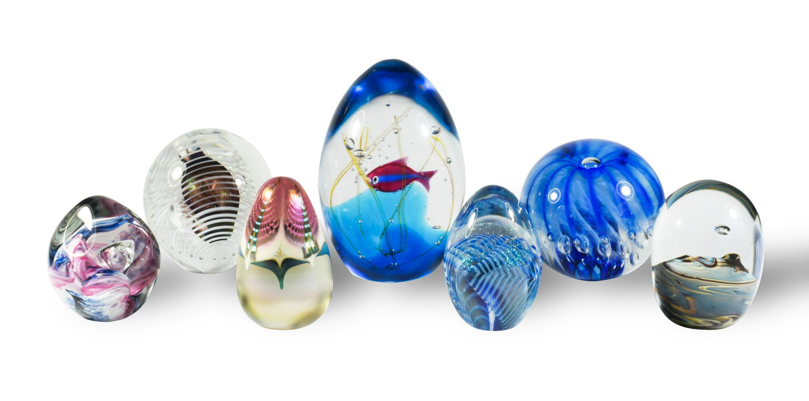 7 Signed Studio Art Glass Paperweights: A group of 7 studio art glass signed paperweights. Includes: 3 by Robert Eickholt, dated 1988 and 1990; 1 by Stuart Abelman, pulled feather design, dated 1986; 1 by Intaglio Art Glass Studio dated 199