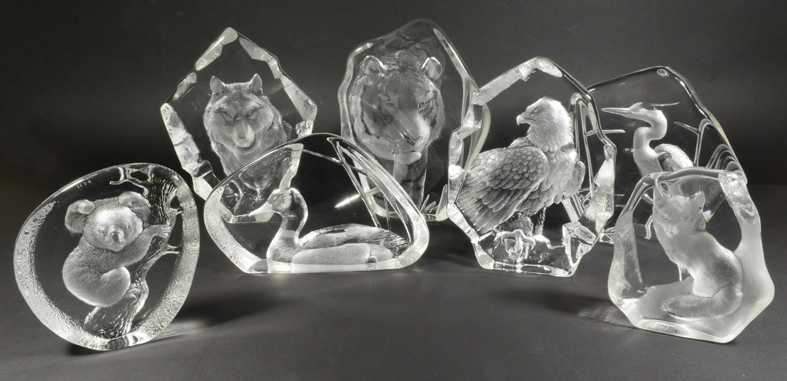 7 Mats Jonasson Etched Lead Crystal Animals: Mats Jonasson (Swedish, b. 1945) etched lead crystal. A group of 7 animal impressions, includes a tiger, fox, duck, wolf, eagle, koala and heron. All are signed and numbered on the bases. Dimensions: 