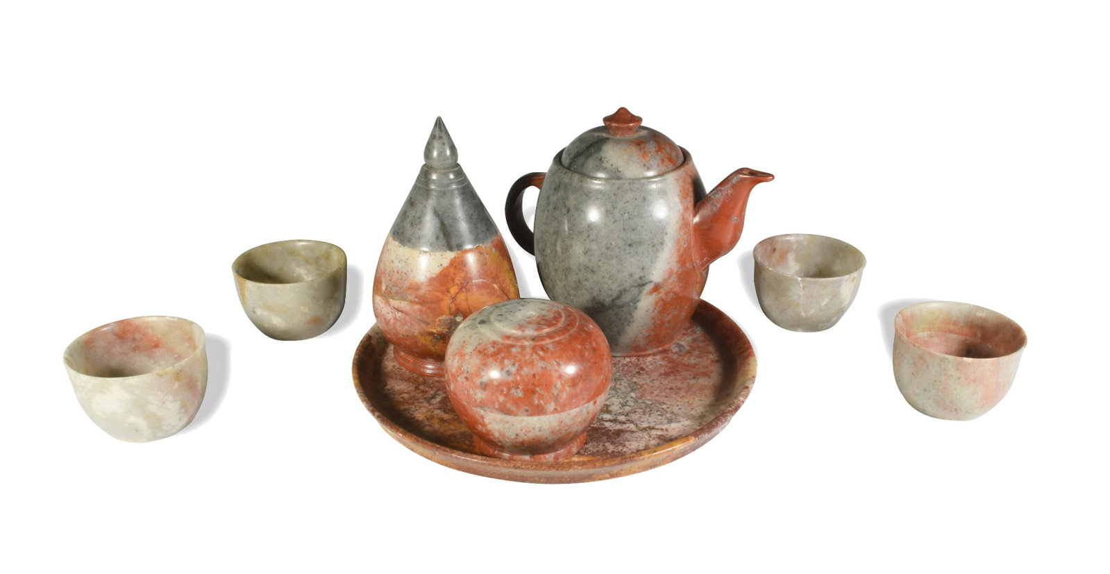 Carved Soapstone Tea Set: A carved soapstone tea set for four. The set includes a serving plate, four teacups, covered sugar bowl, covered creamer, and teapot. Dimensions: serving plate- 1/2 inch tall X 7 1/2 inches diameter; 